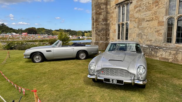 Two classic cars parked in front of a castle by Stephan Leuzinger