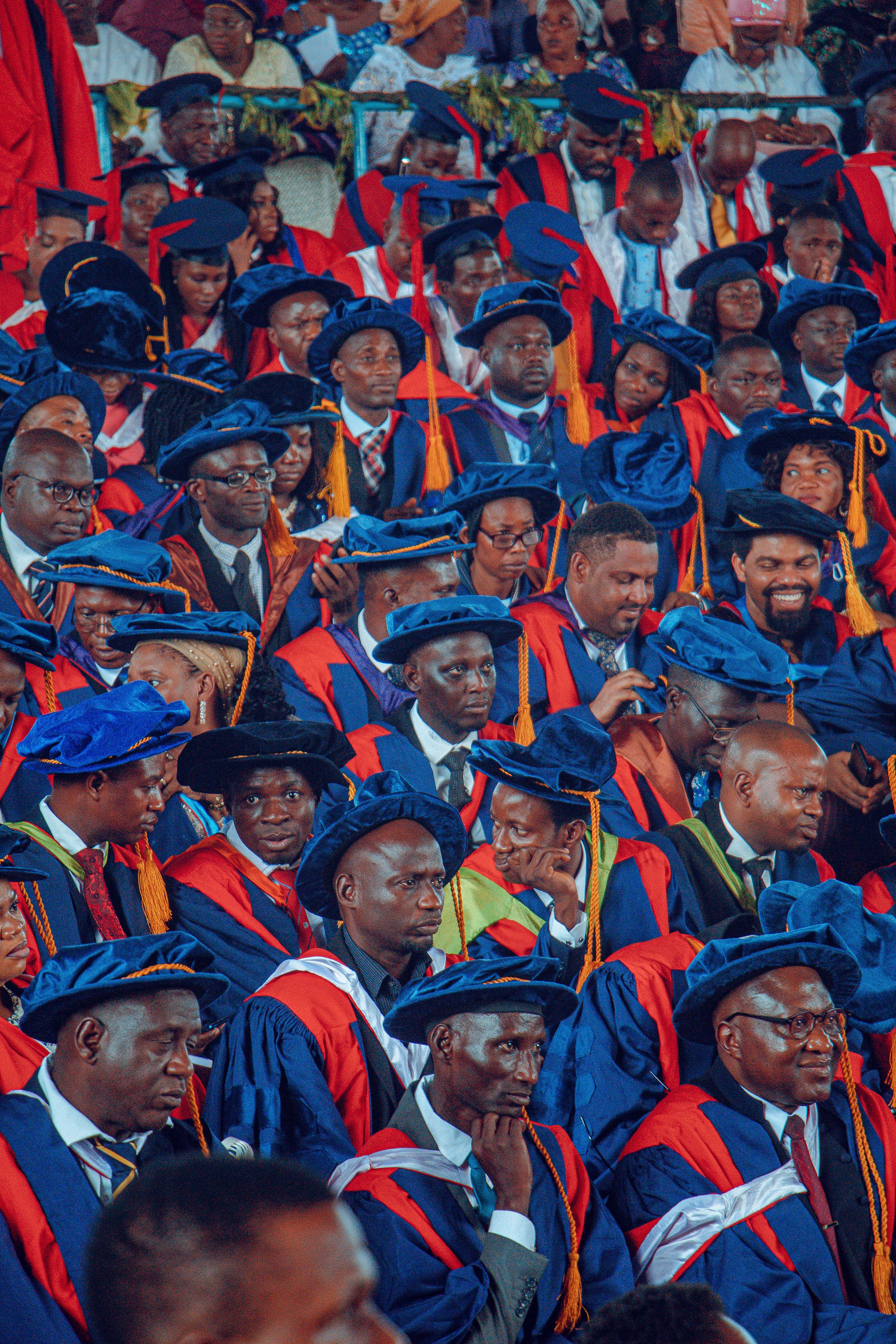 A group of graduates in red and blue caps · Free Stock Photo