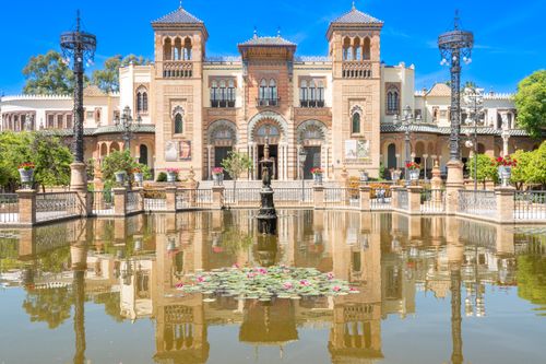 Free Historic architecture of Plaza de América in Seville. Andalusian building reflecting in a pond. Stock Photo