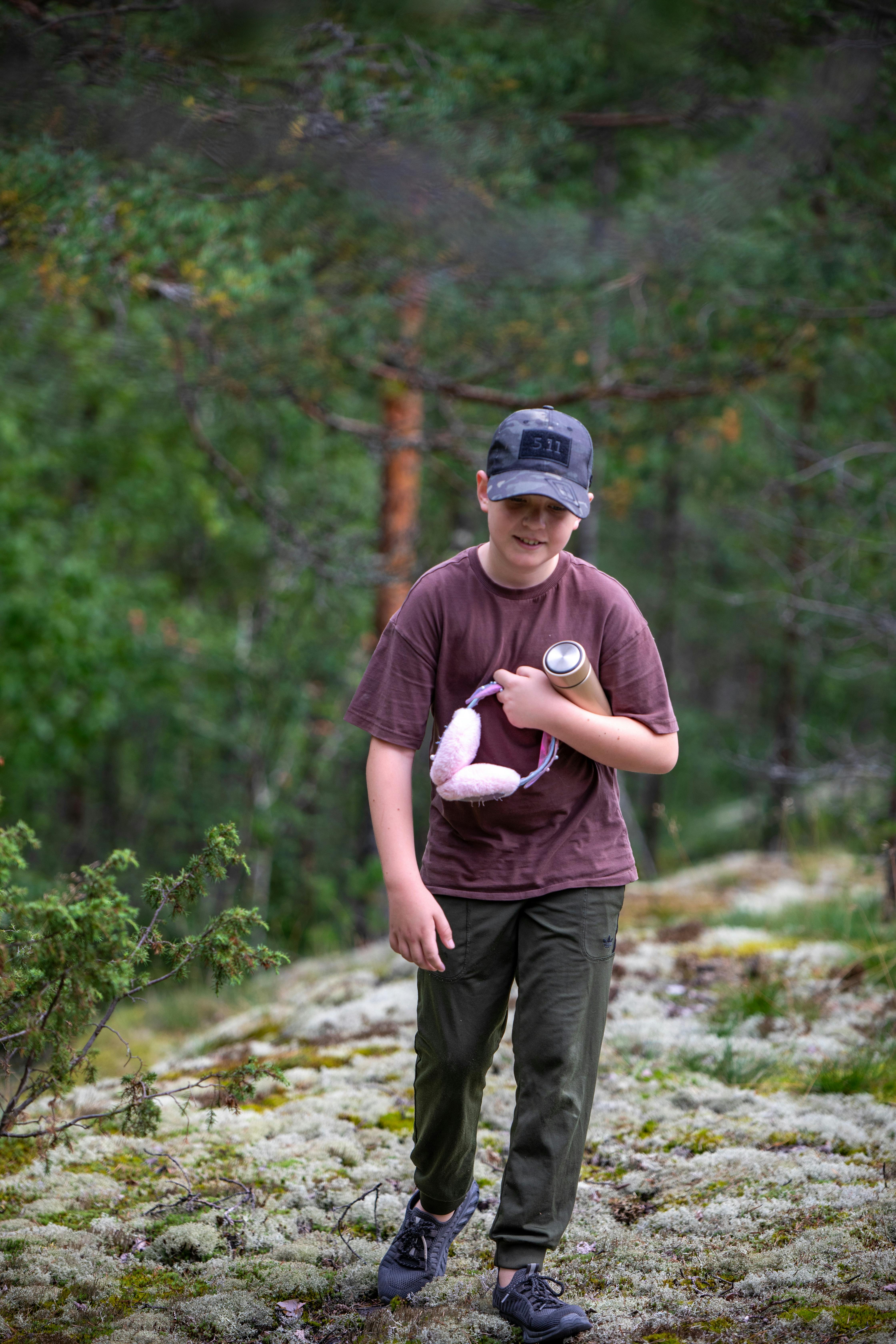 a young boy holding a stuffed animal on a trail