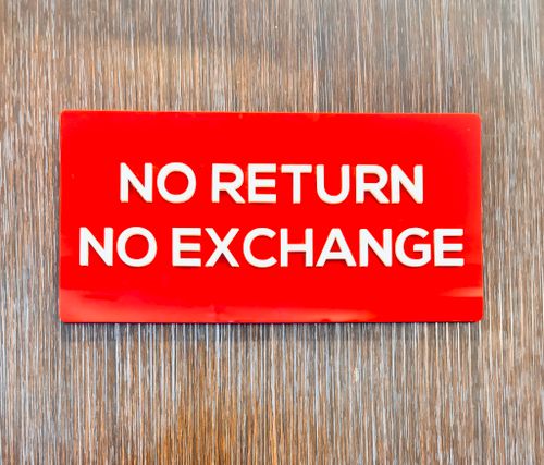 Free Bold red sign with 'No Return No Exchange' message on a wooden backdrop. Stock Photo