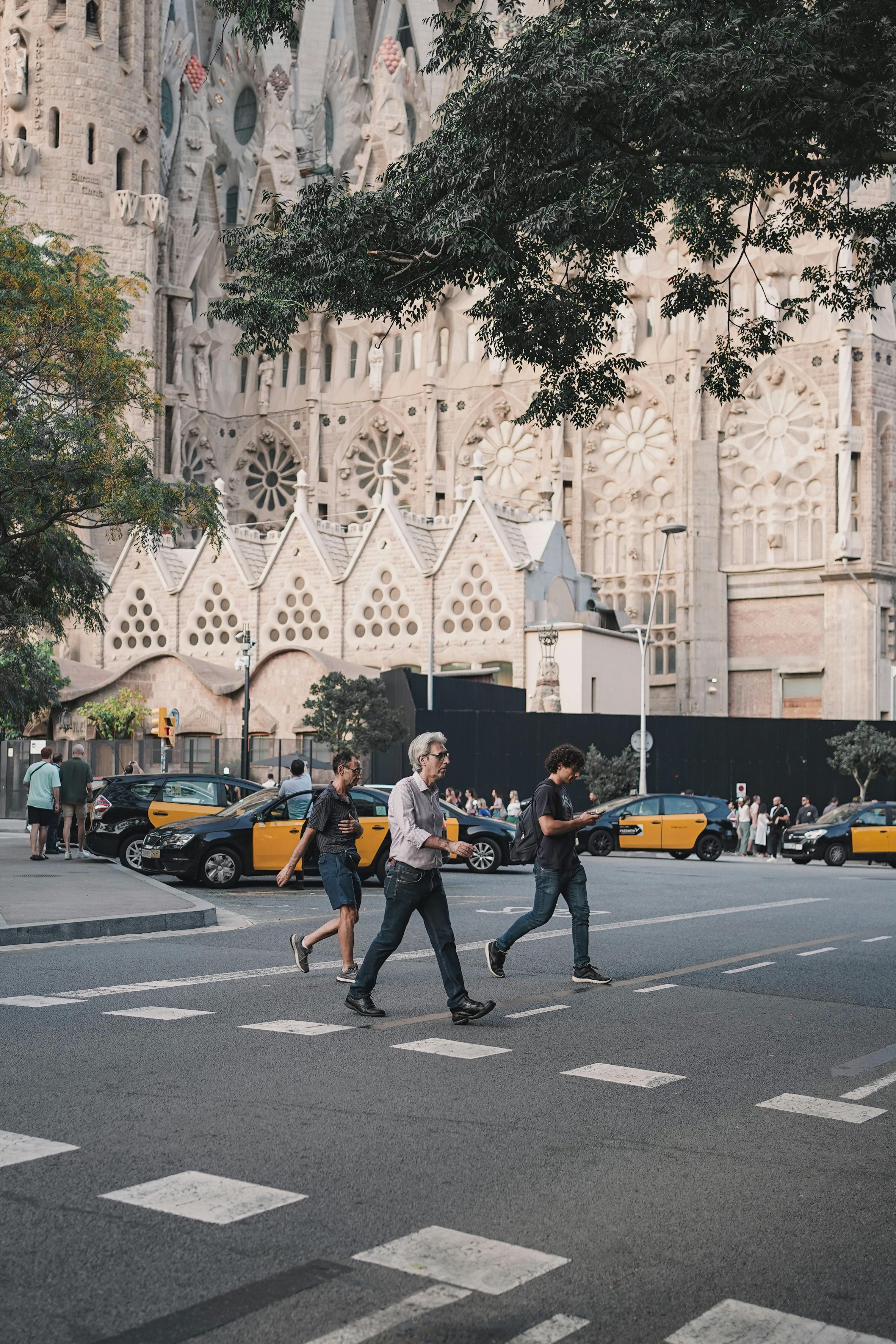 people crossing the street in front of a cathedral