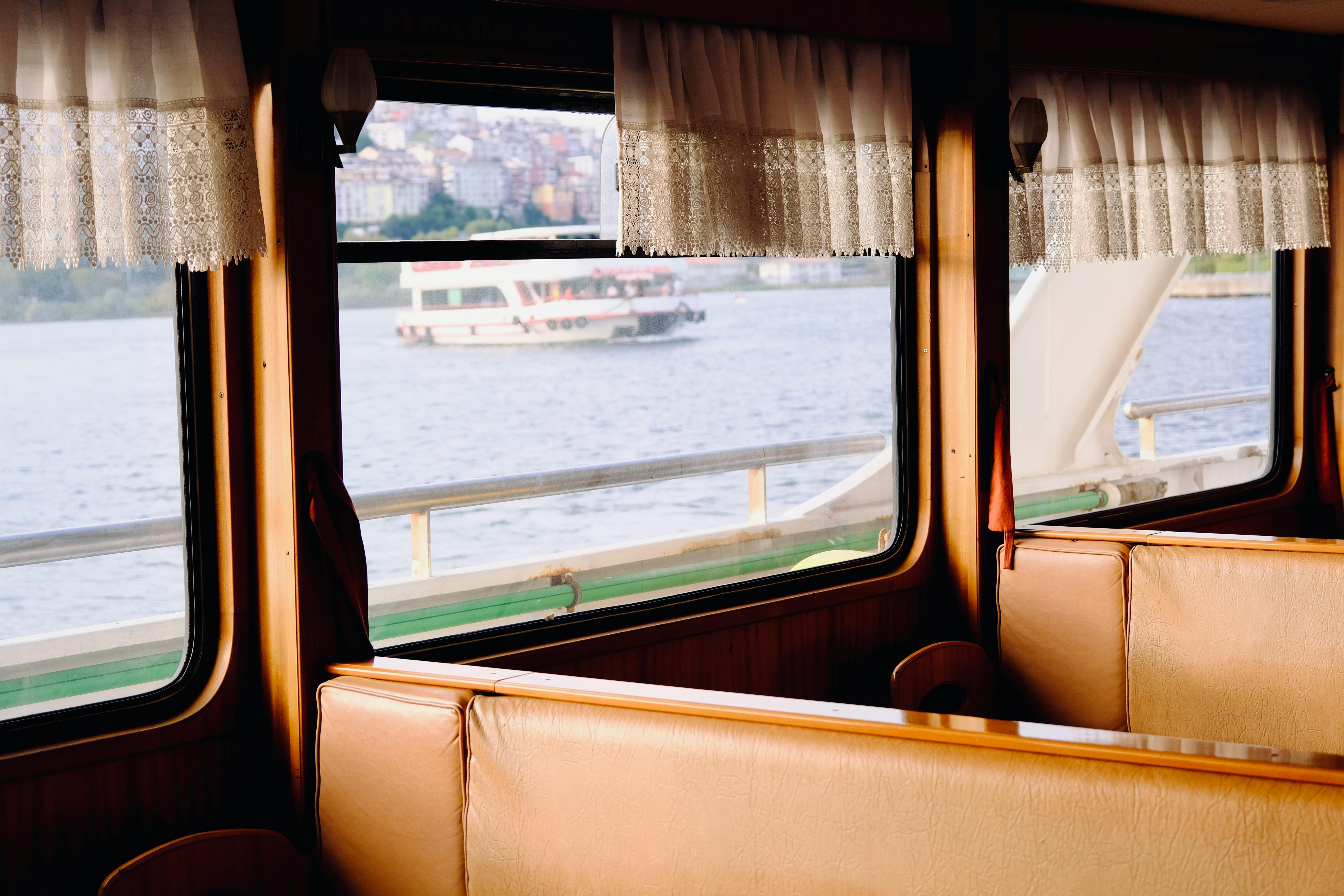 Interior of a ferry with a scenic water view through the windows, evoking travel and leisure.