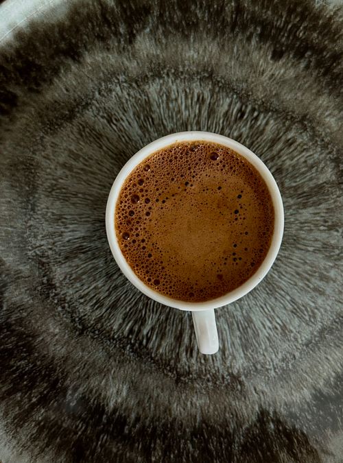 Free A steaming cup of coffee on a rustic textured surface, perfect for cozy mornings. Stock Photo