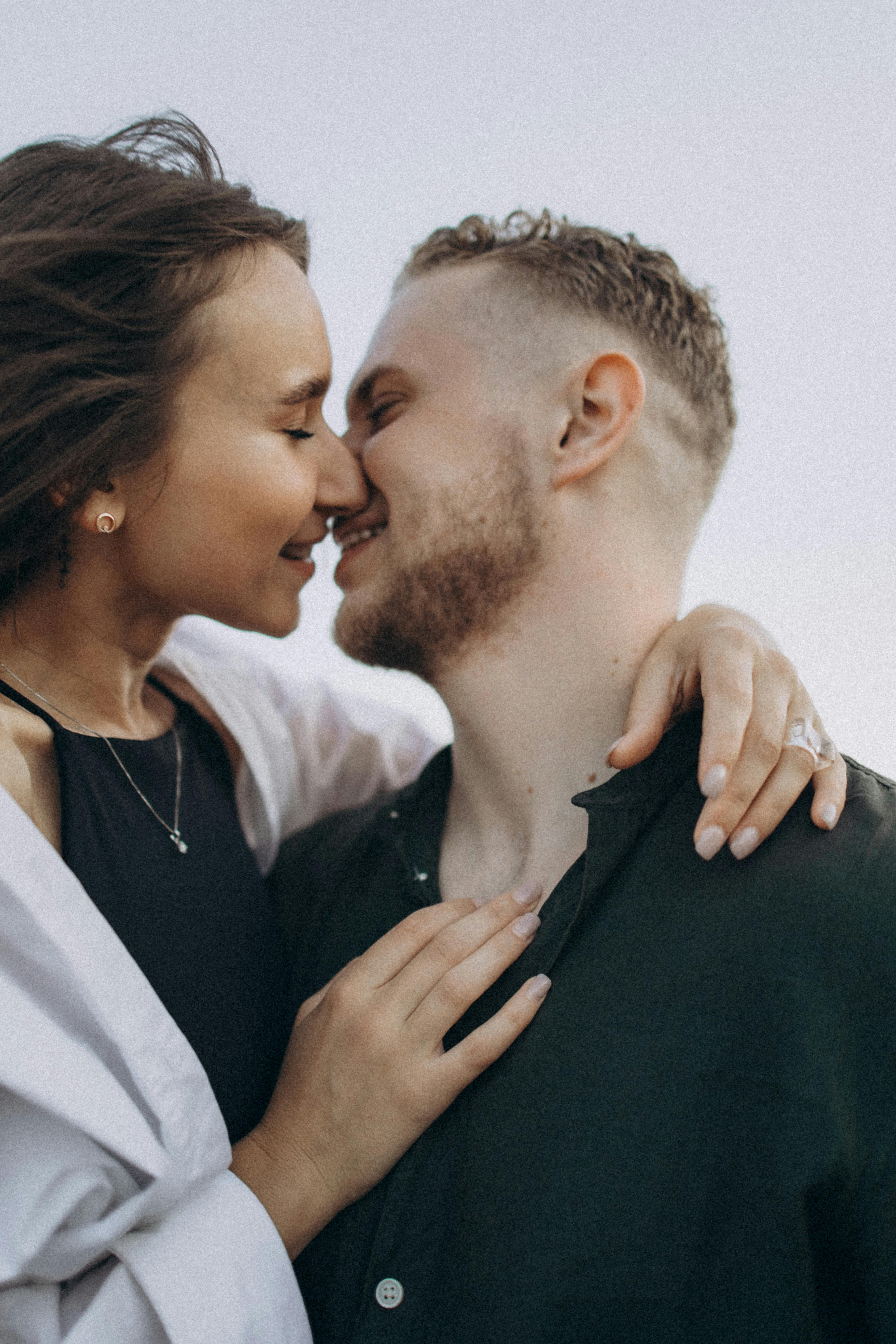 a couple kissing in front of a blue sky