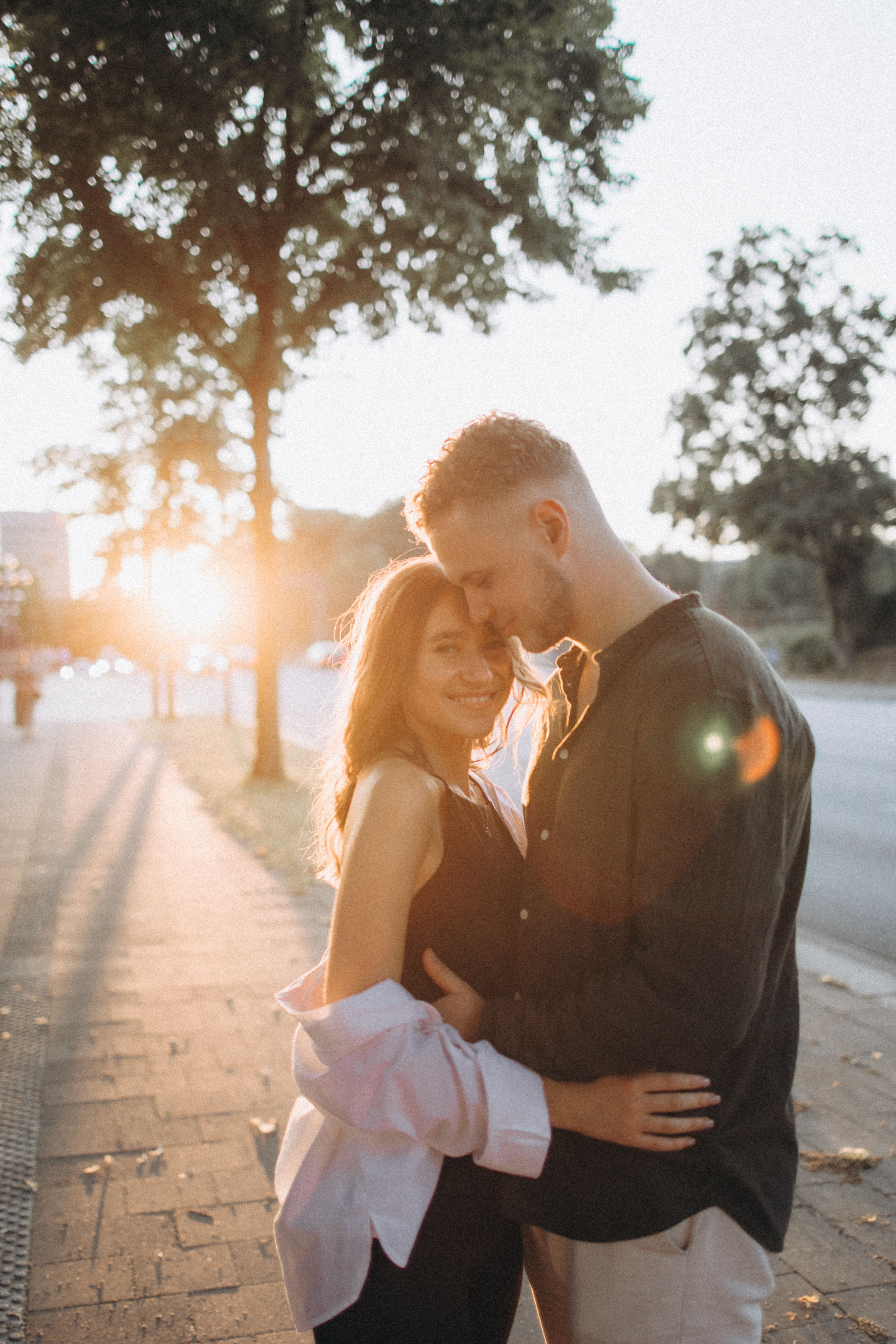 An affectionate couple embracing outdoors during a beautiful sunset.