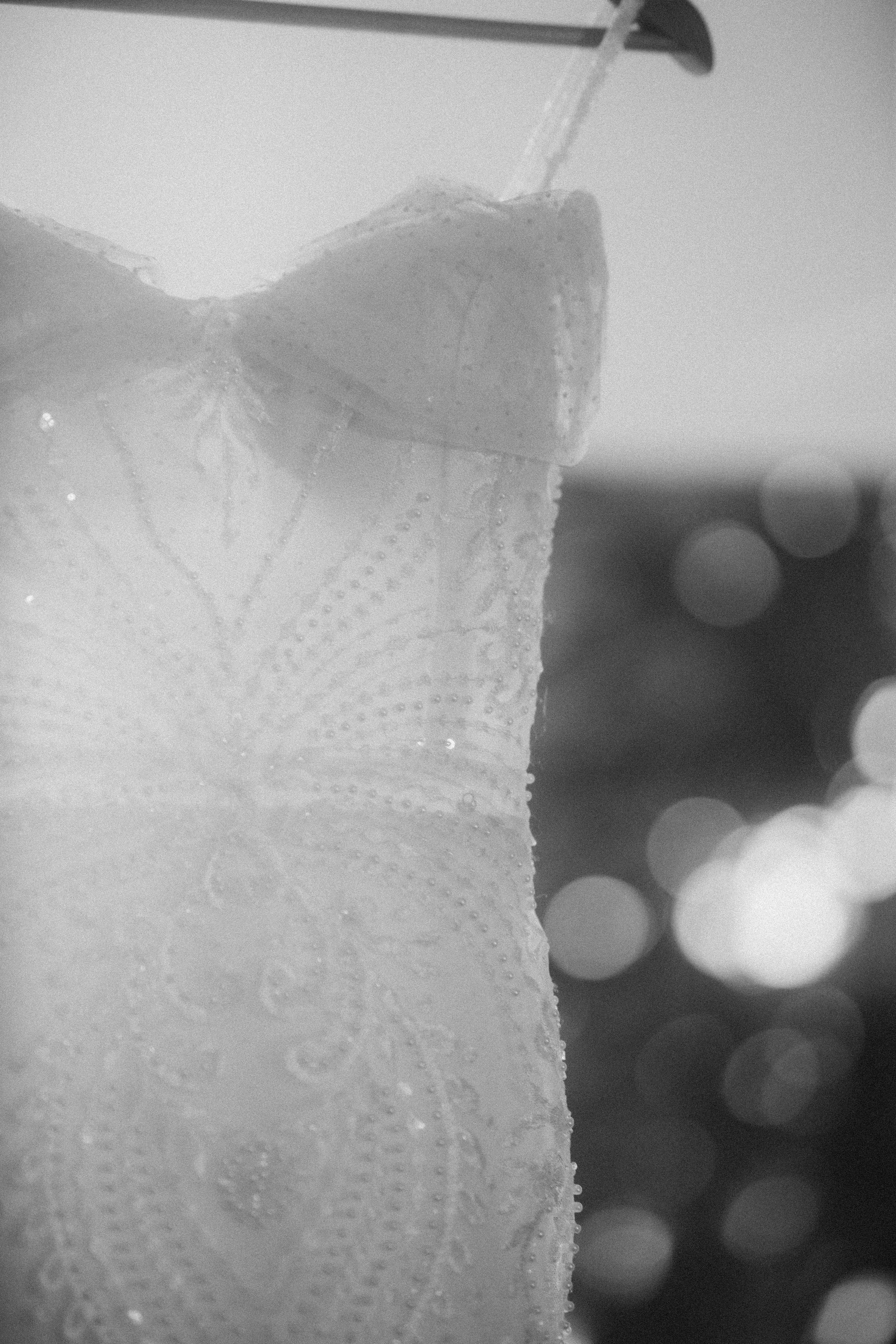 A wedding dress hanging on a hanger in black and white · Free Stock Photo