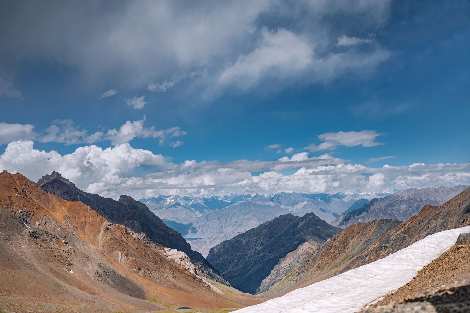 Stunning view of Skardu's mountain peaks with clouds and snow, perfect for adventure seekers.