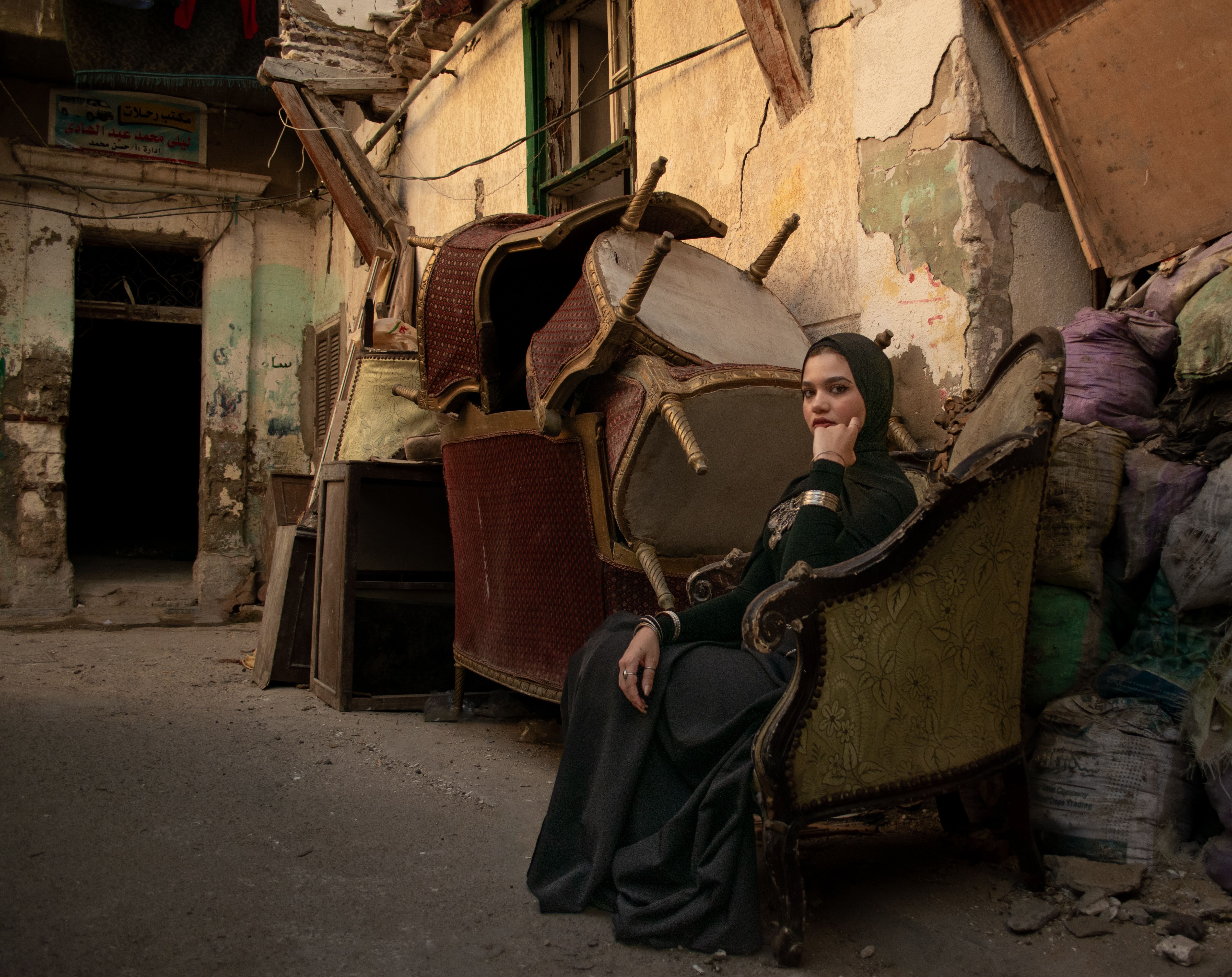A woman sitting in an old chair in a ruined building · Free Stock Photo