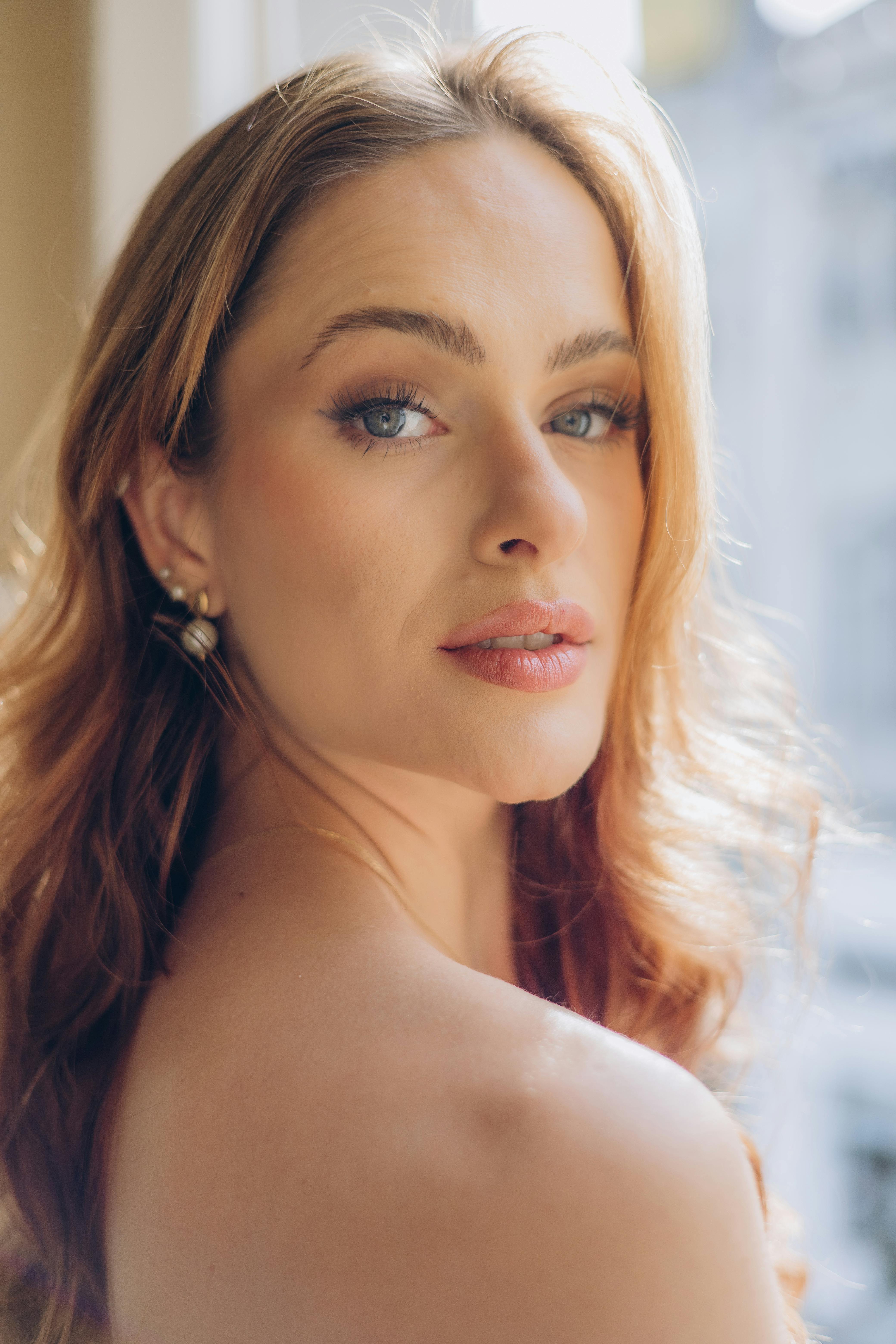 A serene and elegant portrait of a woman by the window, capturing natural light and grace.