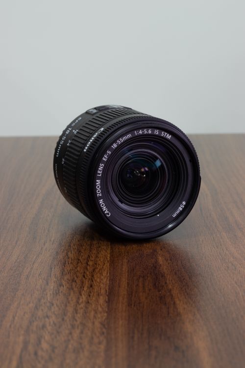 Free Capture the beauty of a Canon zoom lens with detailed focus on a wooden table, perfect for photography enthusiasts. Stock Photo