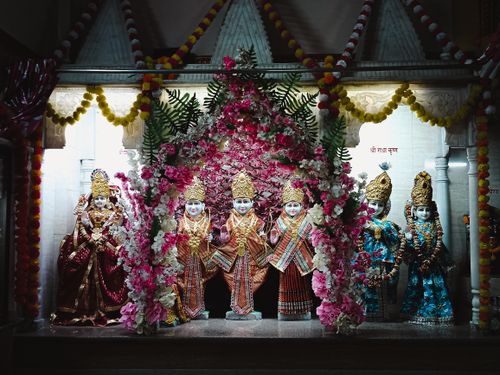 Free Colorful statues of Hindu deities adorned with flowers and traditional garments in a temple setting. Stock Photo
