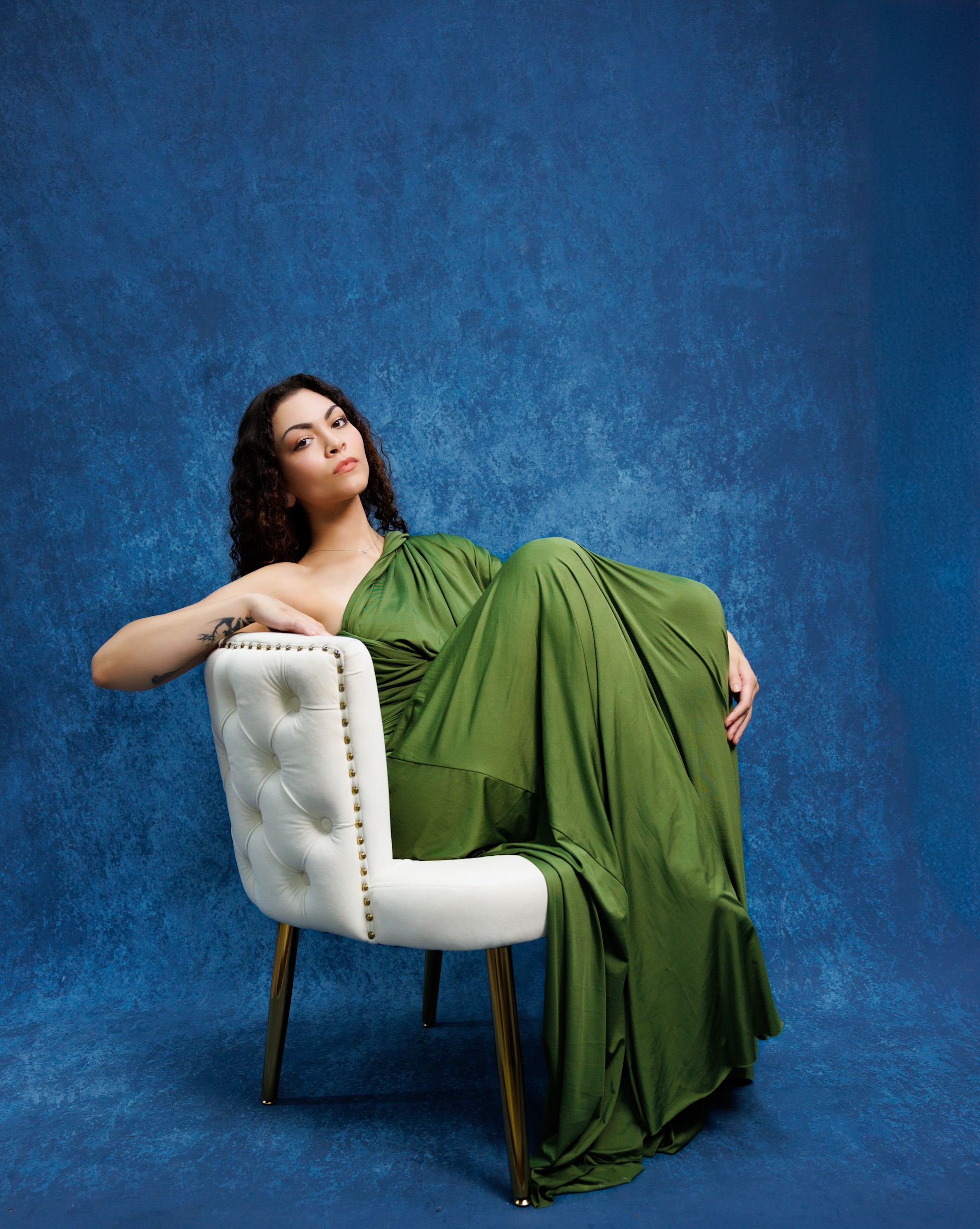 A woman in a green dress sitting on a chair · Free Stock Photo
