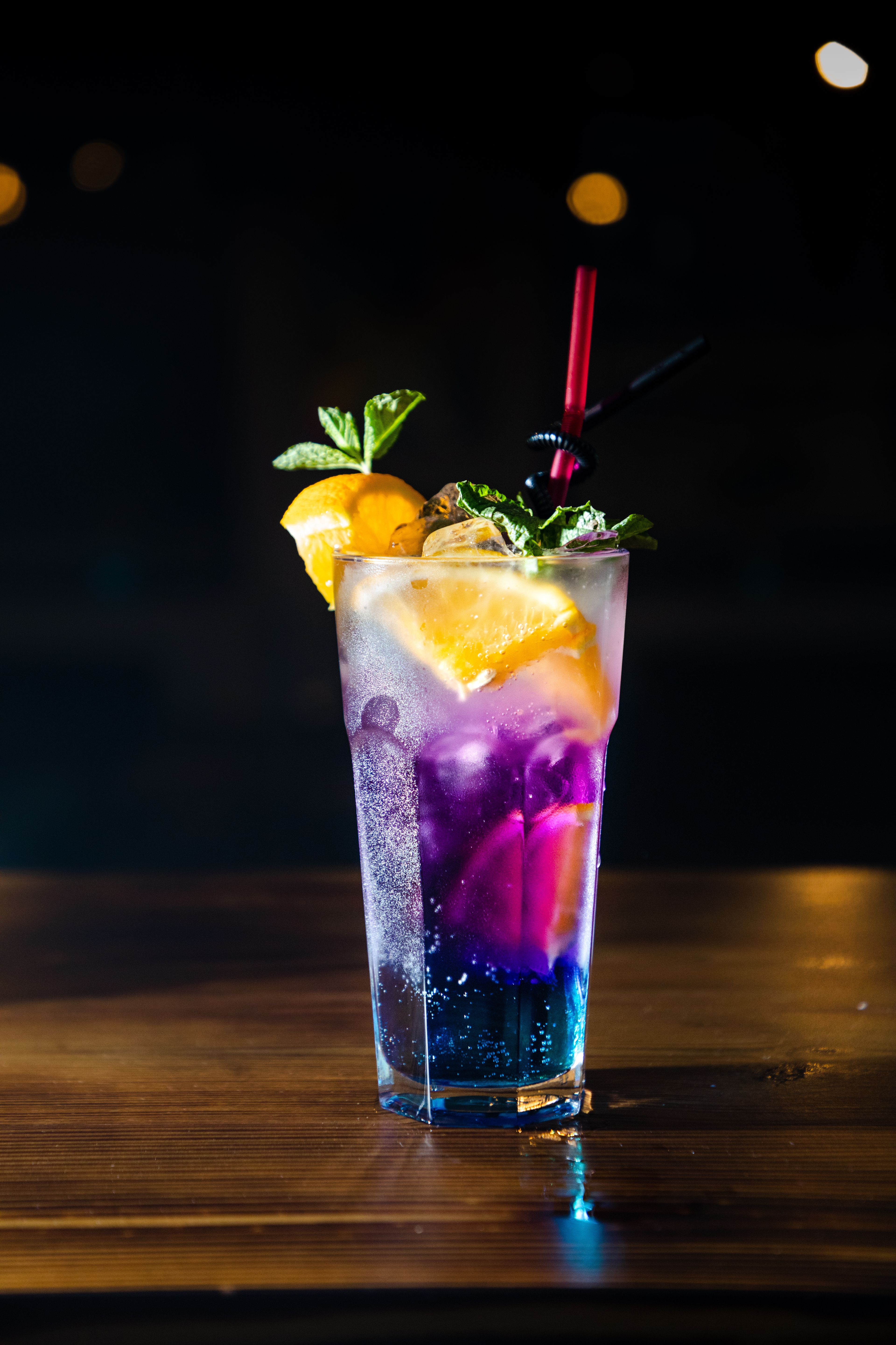 Dark berry cocktail garnished with dried citrus