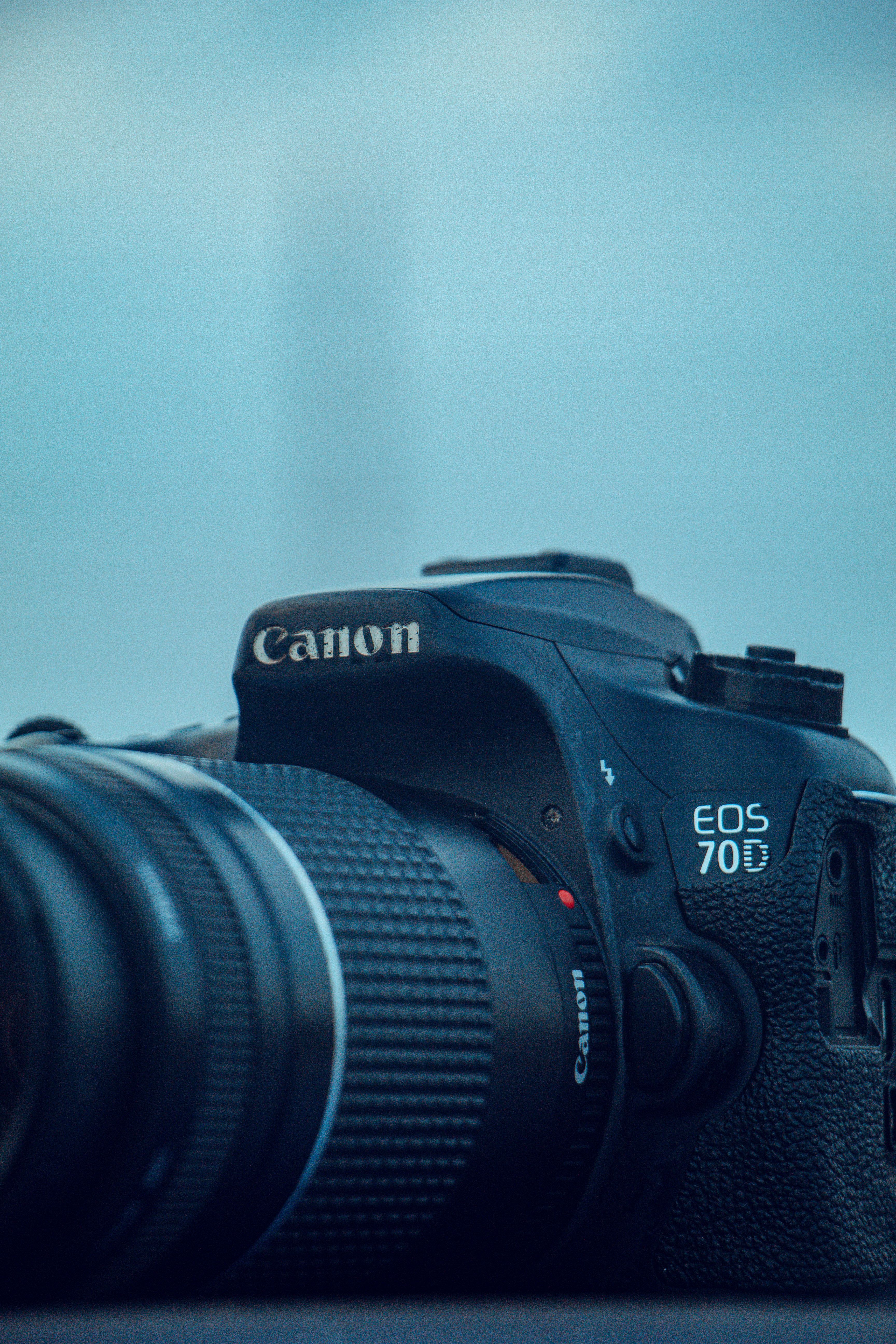 Detailed view of a Canon DSLR camera with a telephoto lens, ideal for photography enthusiasts.
