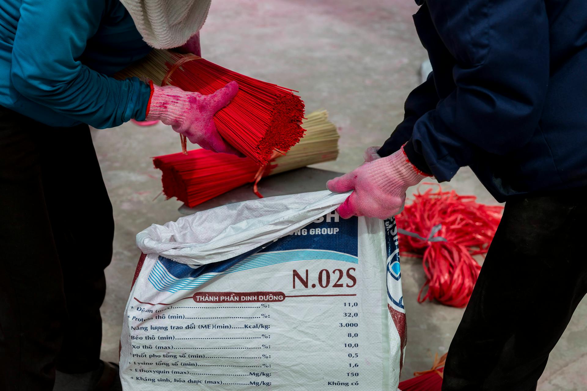 Two people are sorting out bags of red and white