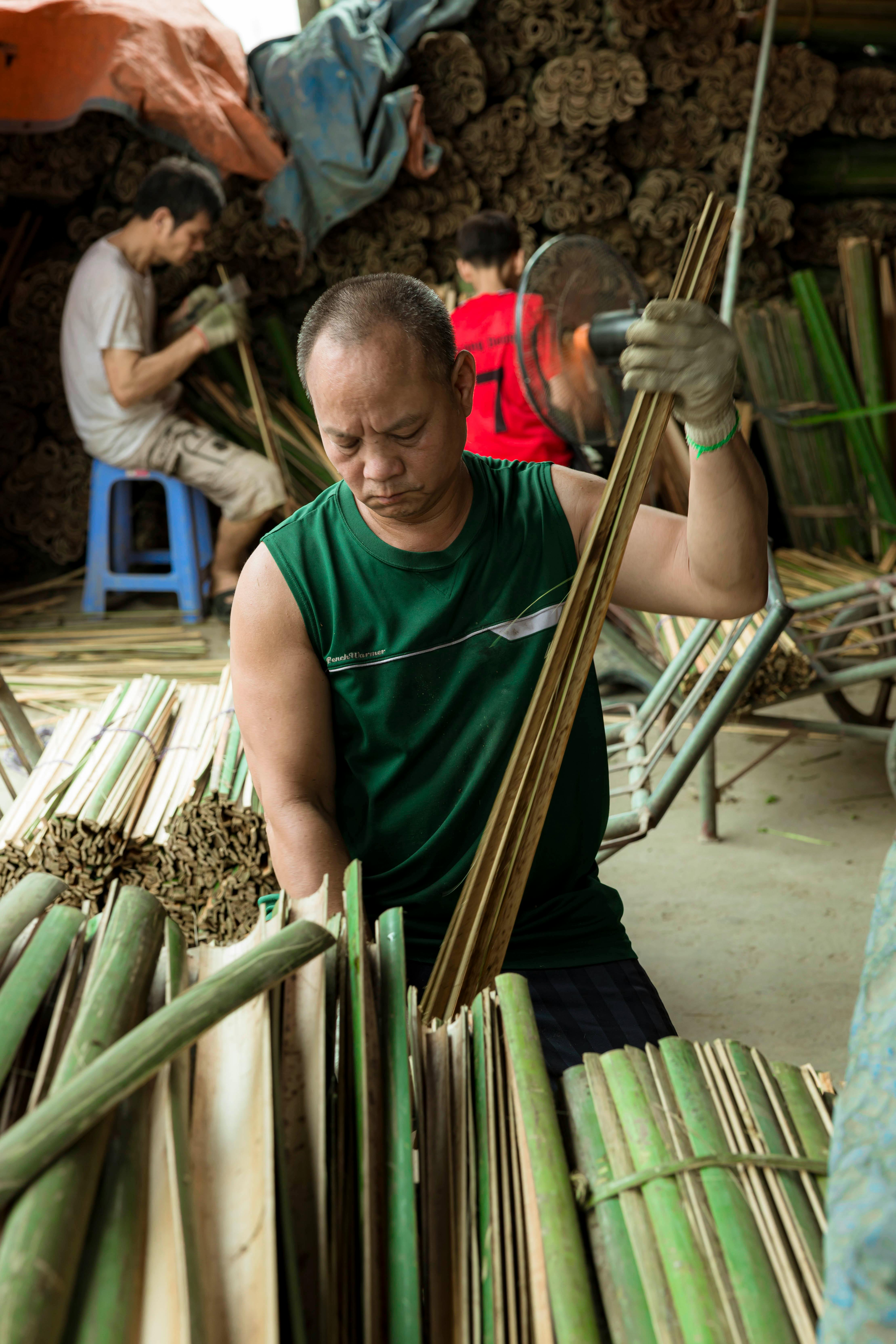 a man is working on bamboo sticks in a workshop