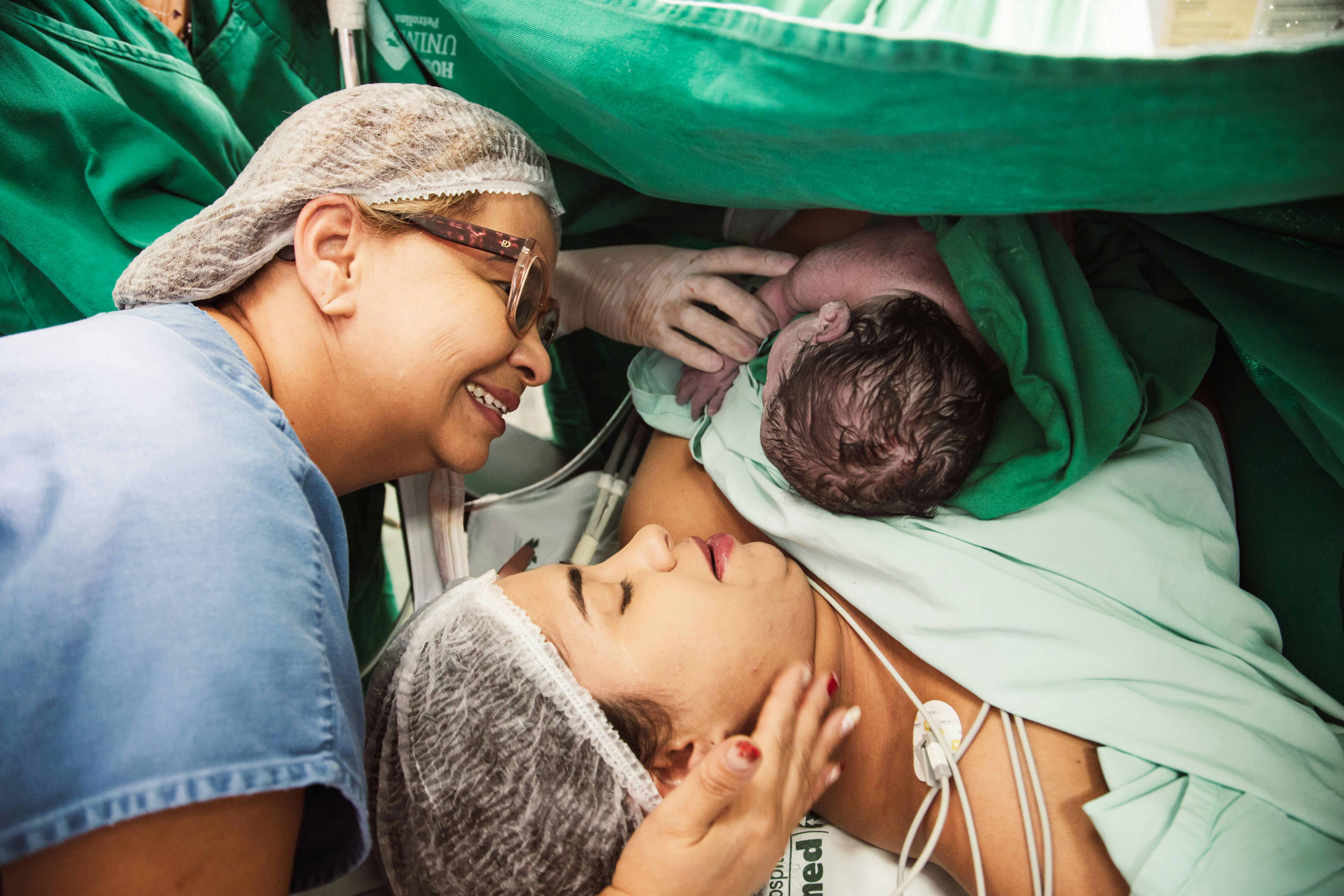 a woman is holding a baby in a hospital