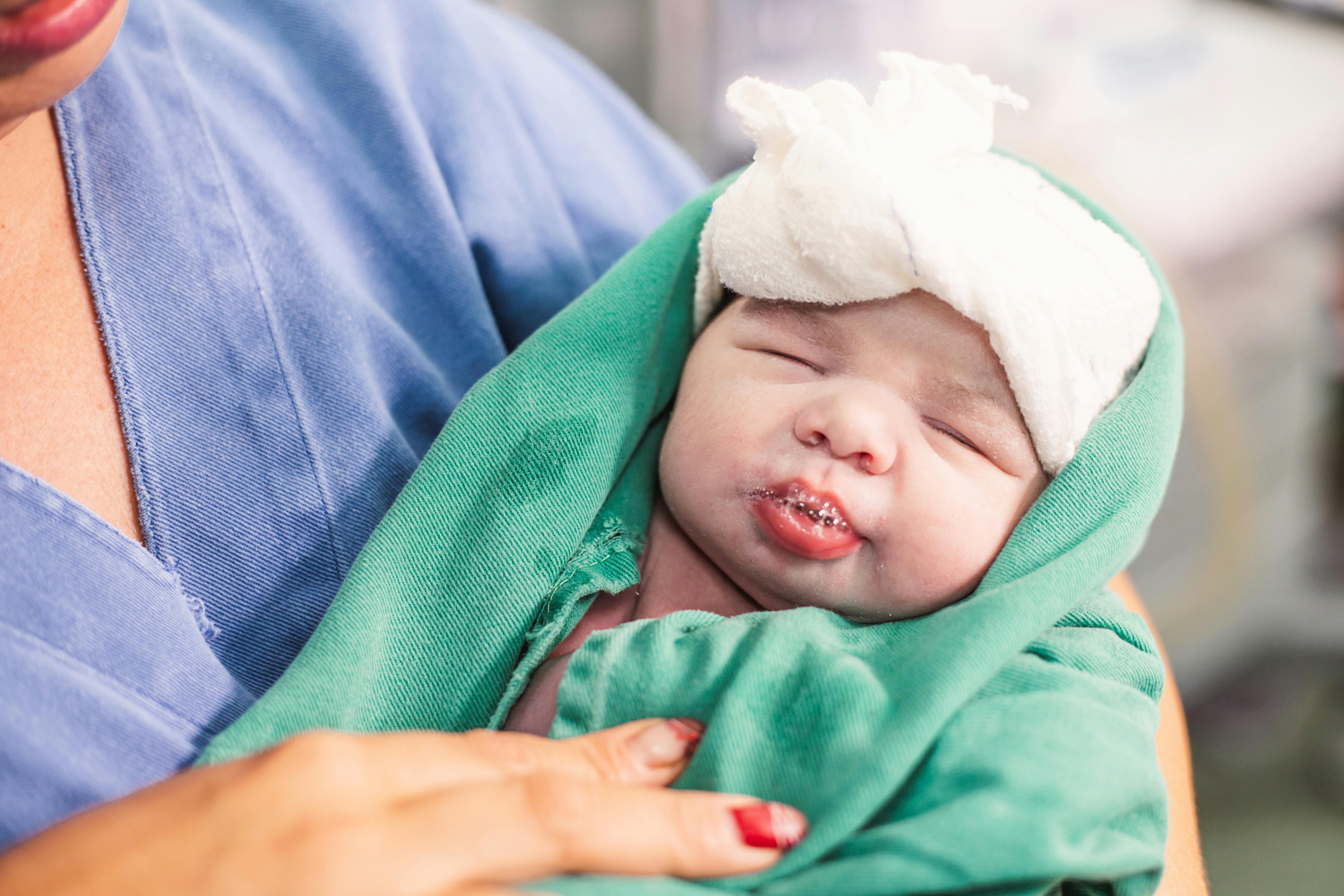 a woman holding a baby wrapped in a blanket