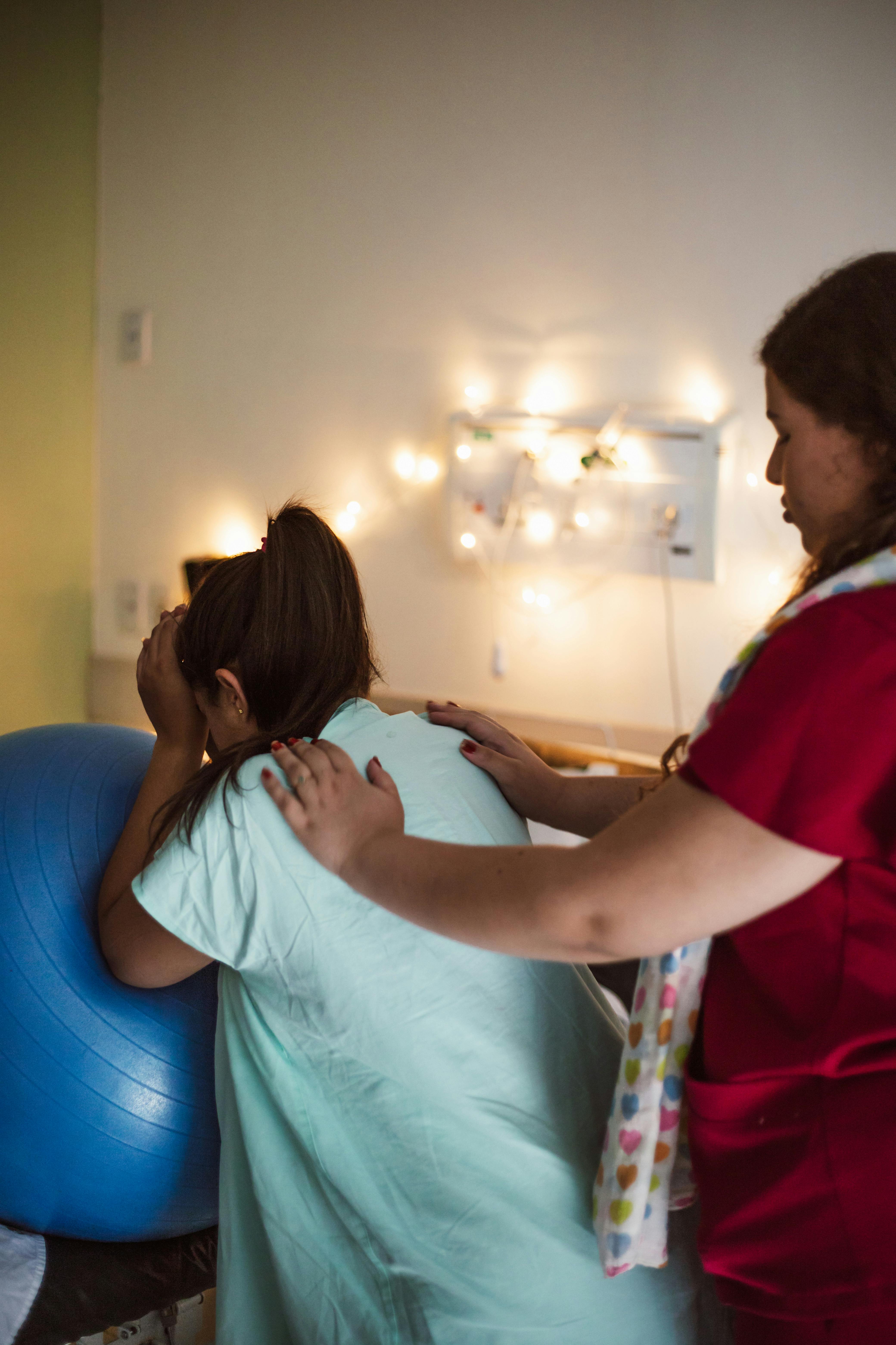 a woman is holding a baby in a hospital room