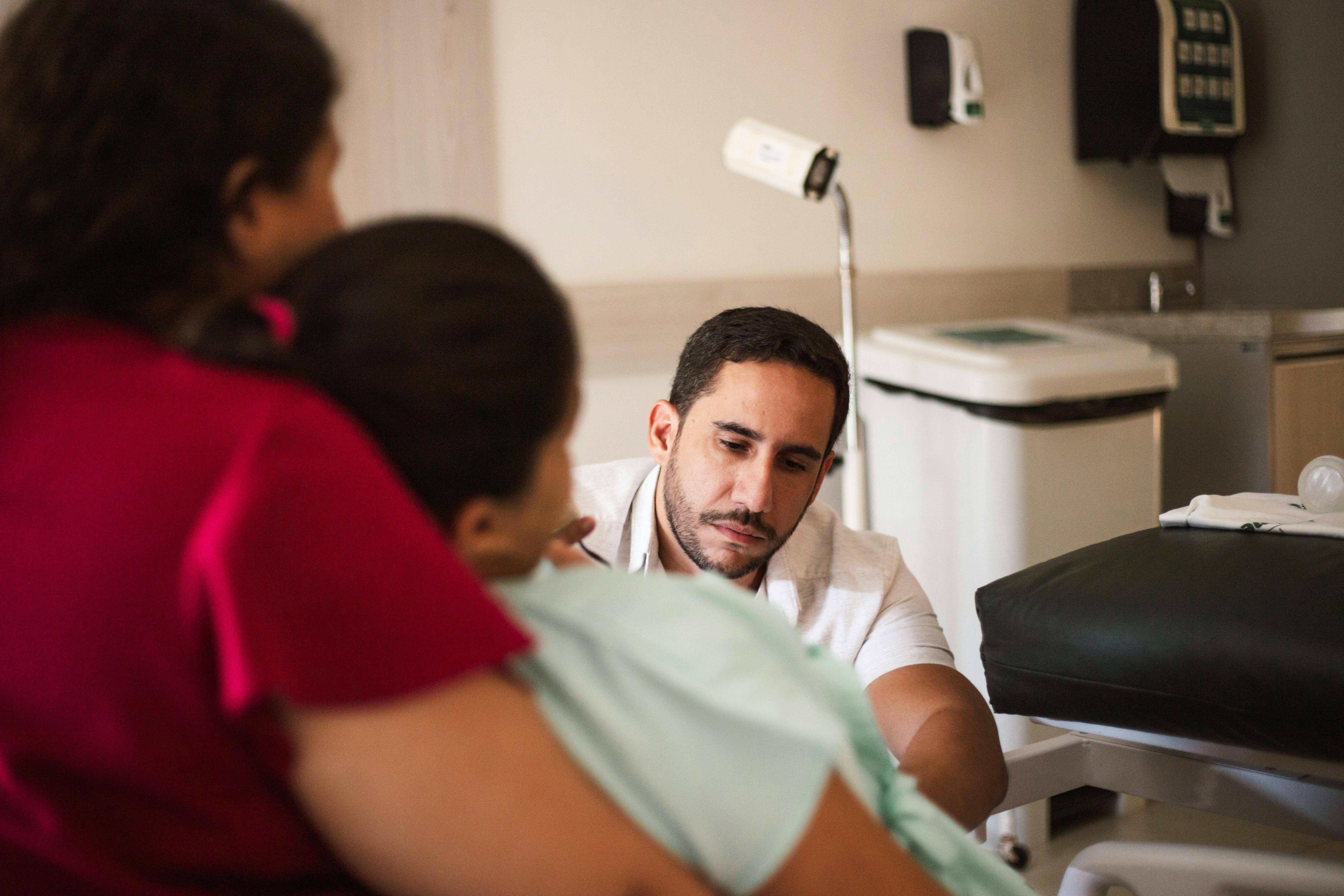 a man and woman are talking to a woman in a hospital