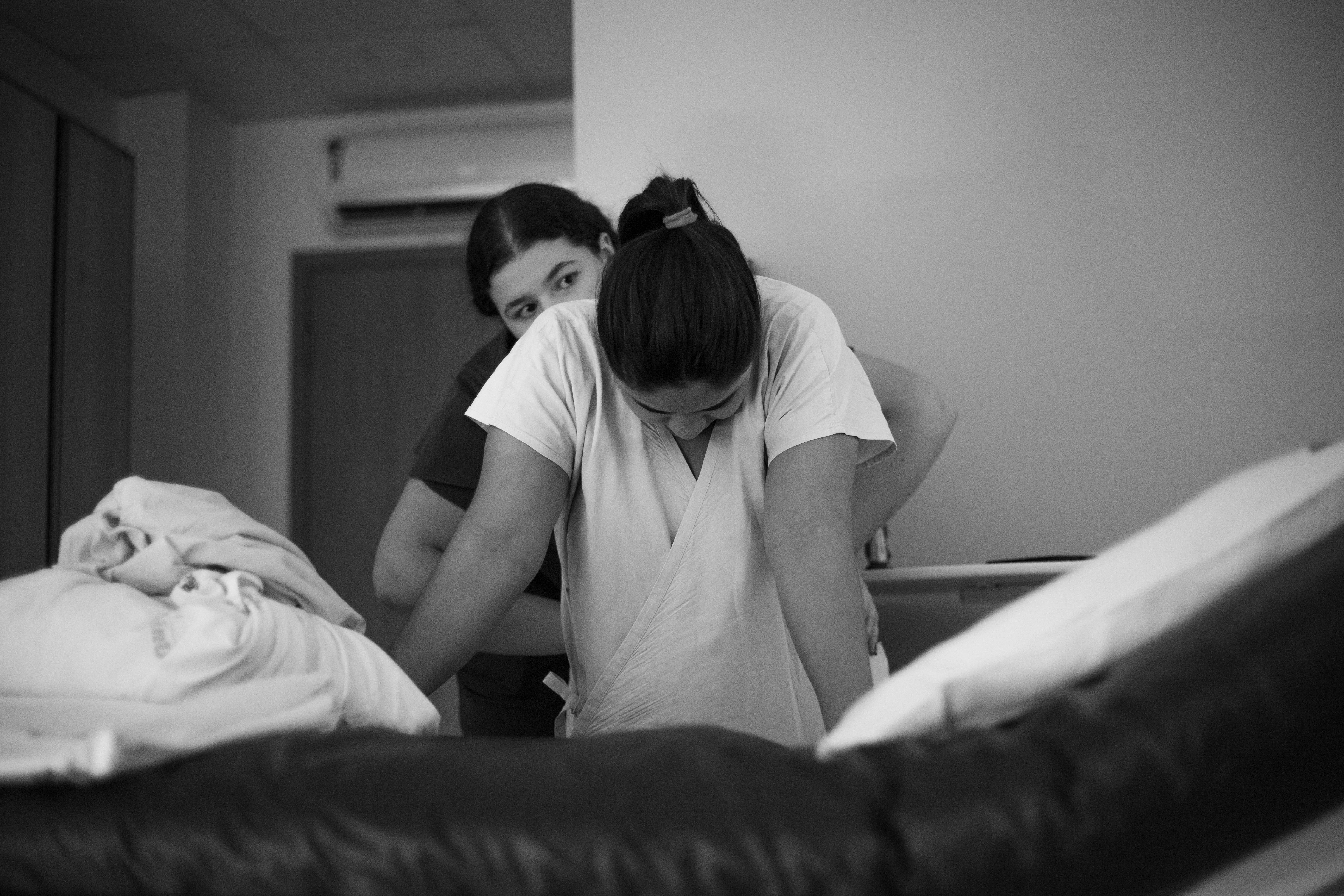 a woman is helping another woman to get into bed