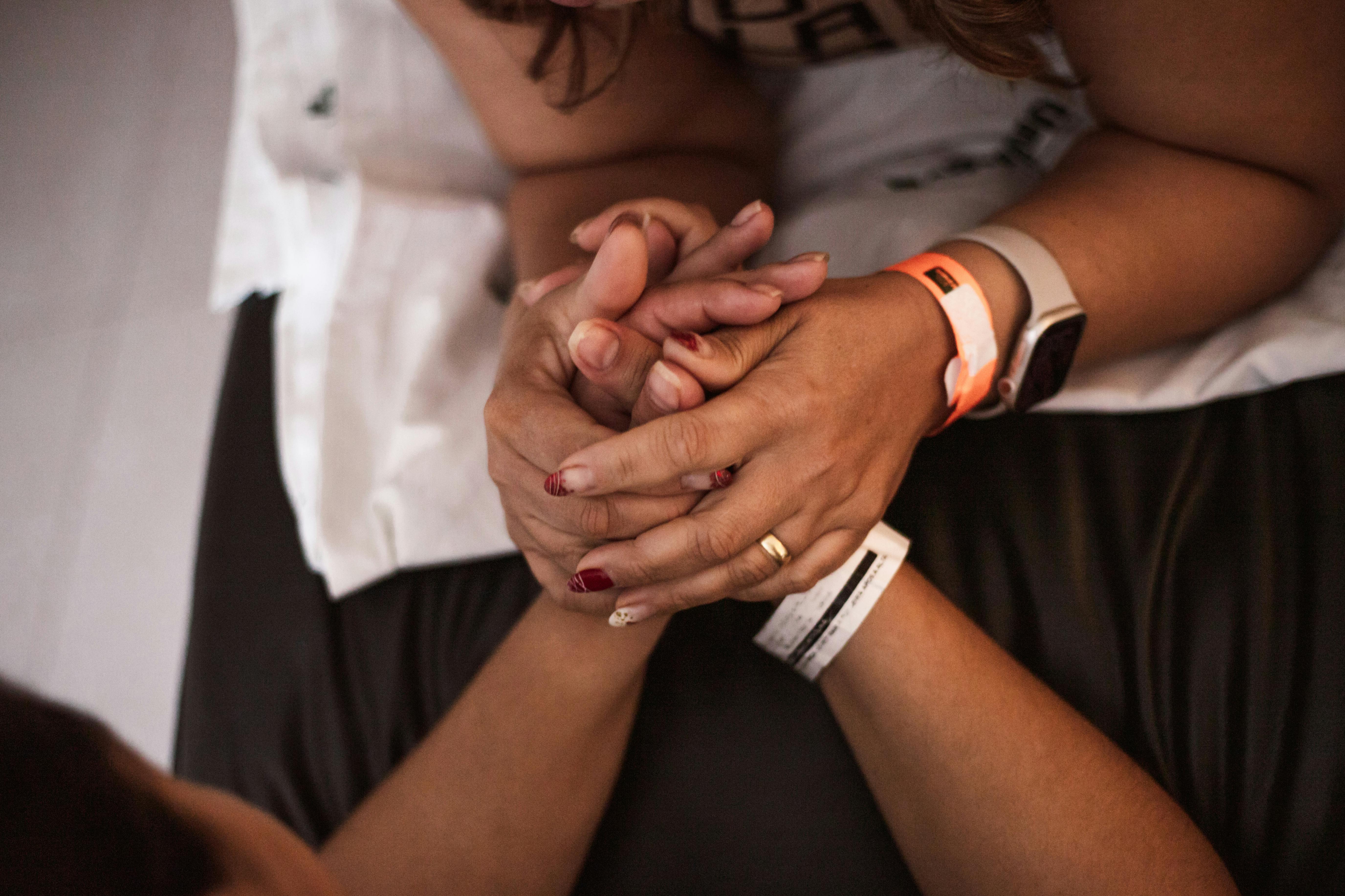 two women holding hands with a watch on their wrist