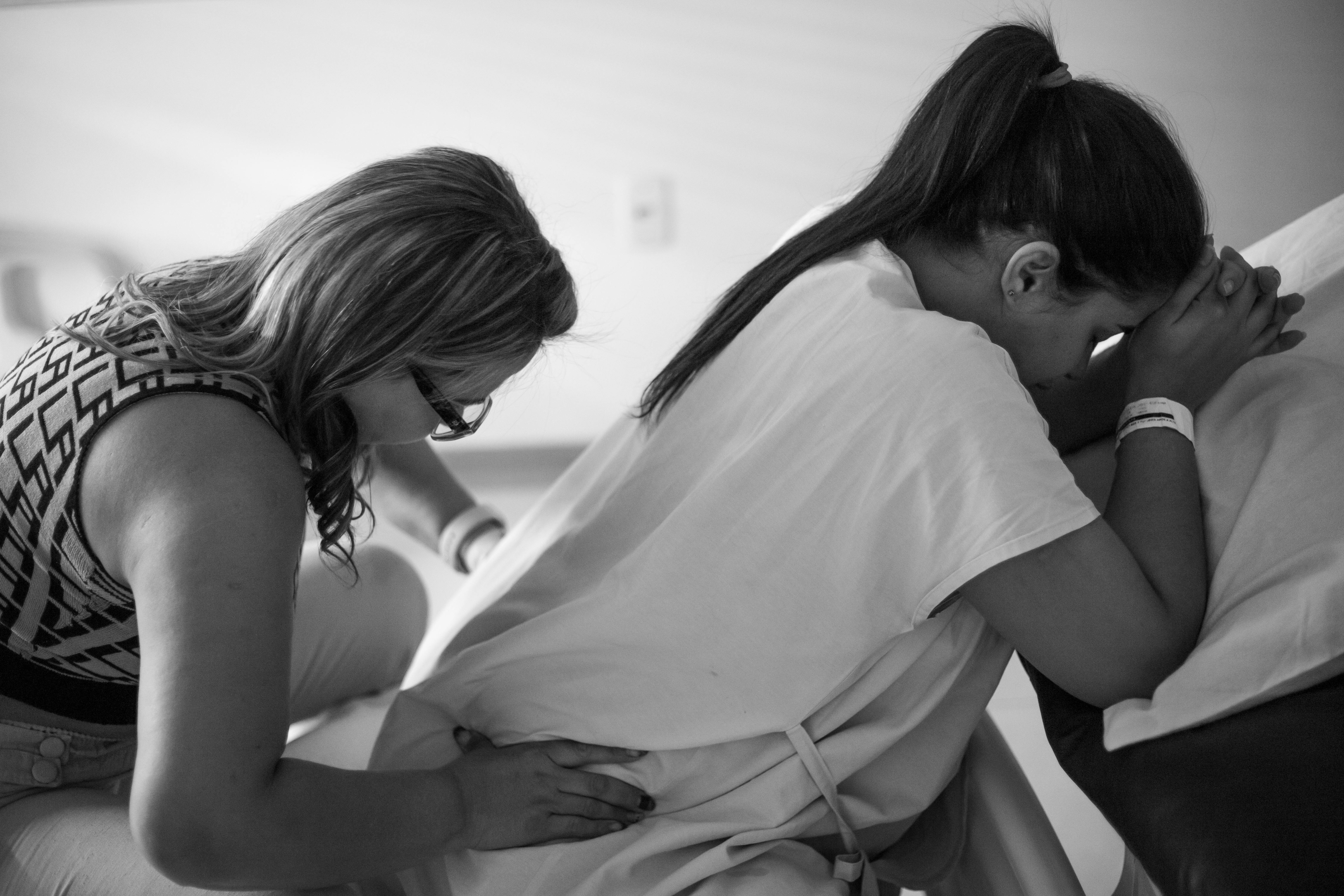 a woman is sitting on the floor with her hands on her stomach