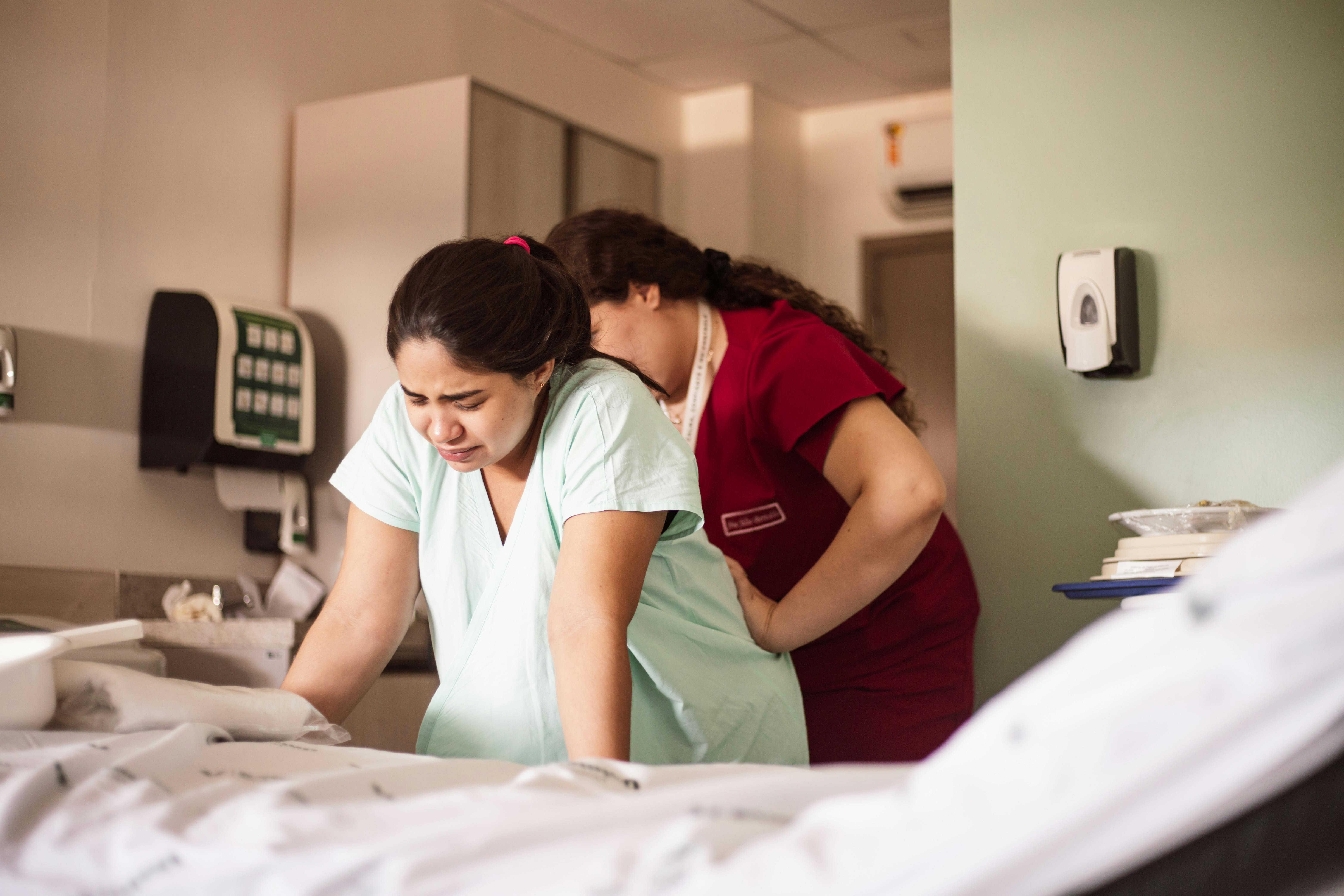 nurse assisting a patient in a hospital bed