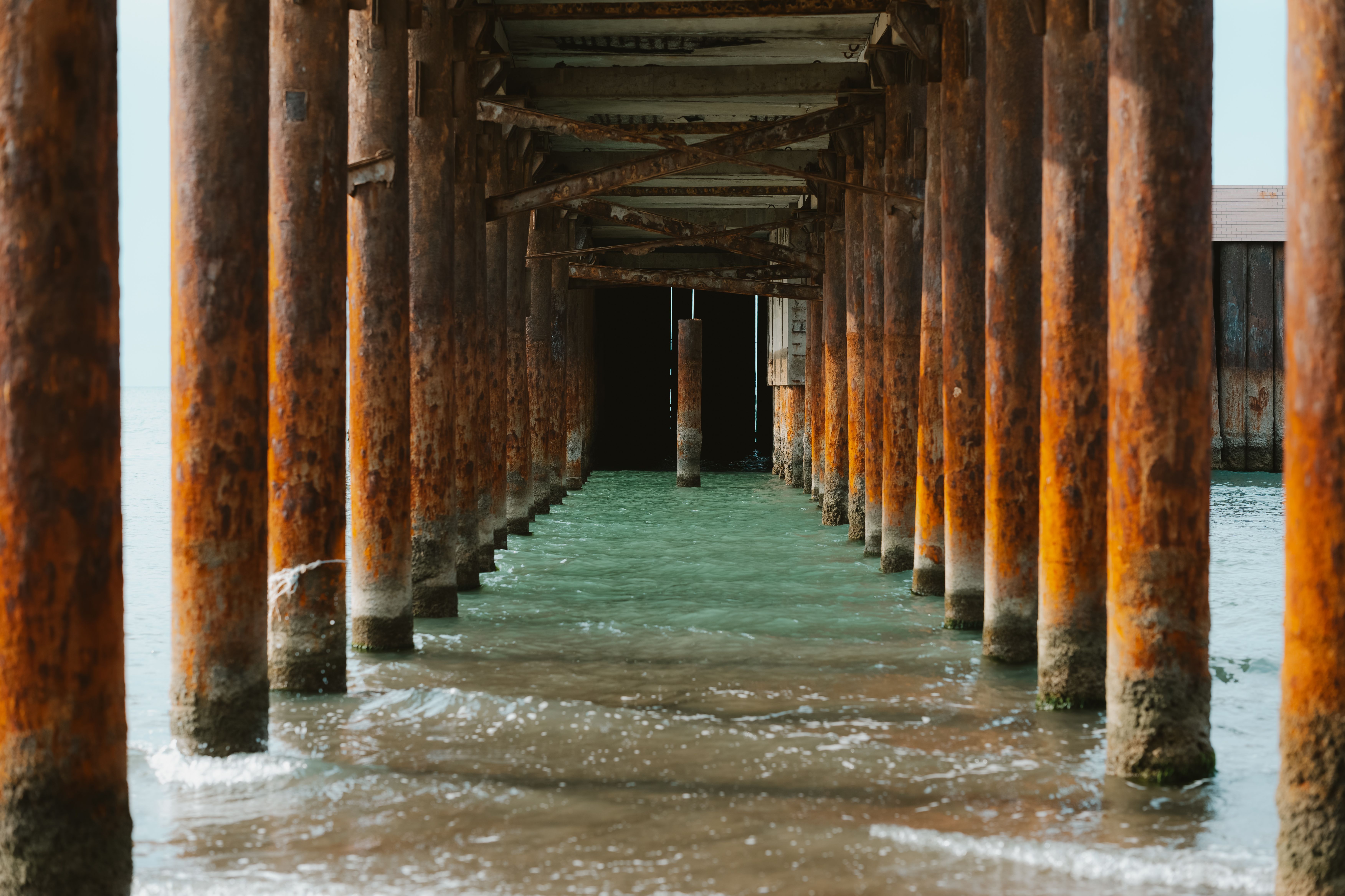 Hydraulic pier foundation repair in Corpus Christi showing heavy machinery installing steel piers beneath a building fou