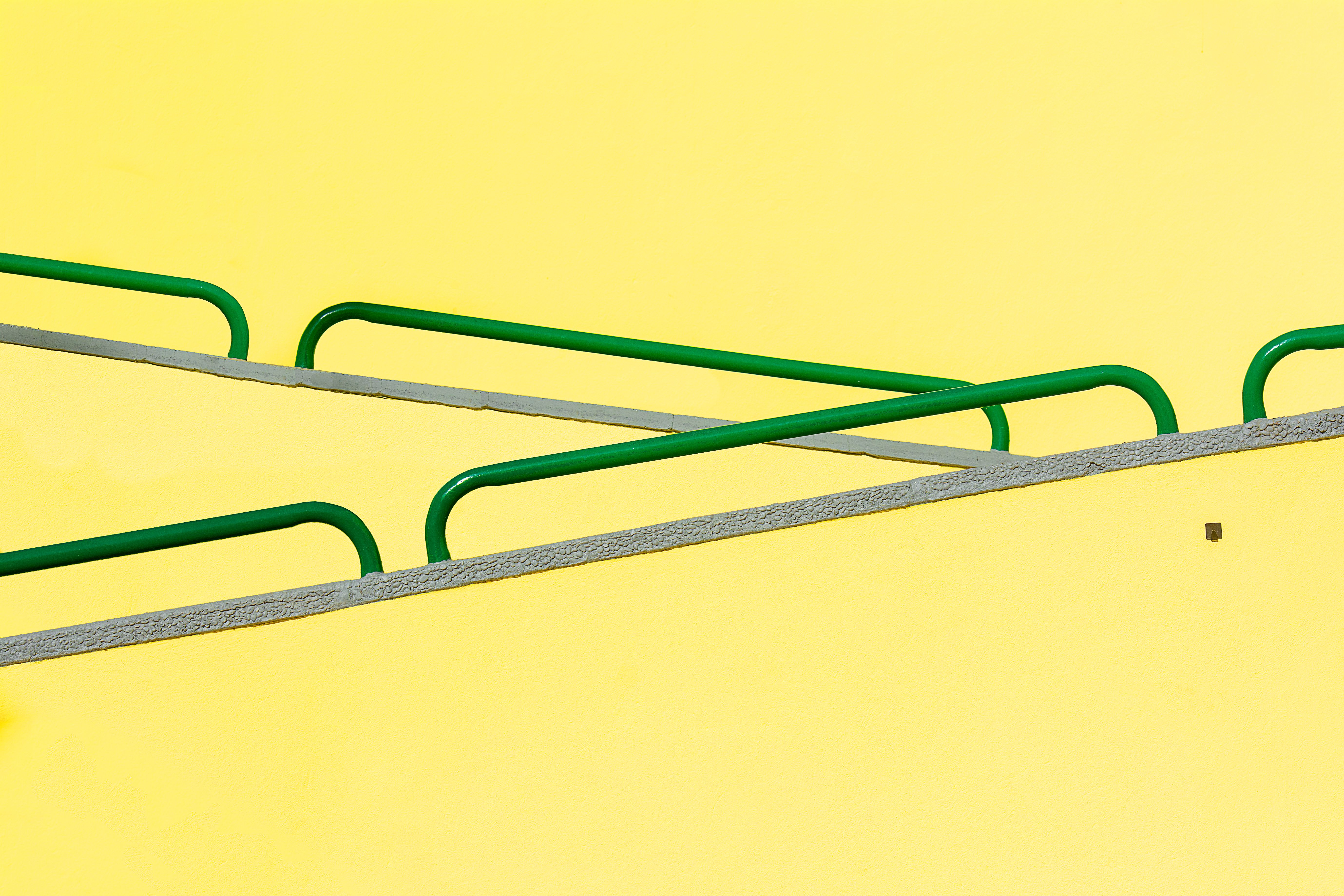 A green and yellow railing with two bars · Free Stock Photo