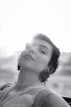 Graceful black and white portrait of a woman adorned with pearls, exuding vintage elegance.