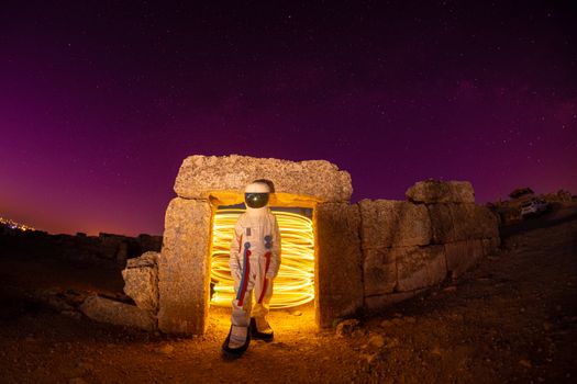 Portale energetyczne: kompletny przewodnik po bramach świadomości 17 Astronaut in a rocky landscape with swirling lights under a starry night sky, evoking mystery and exploration.