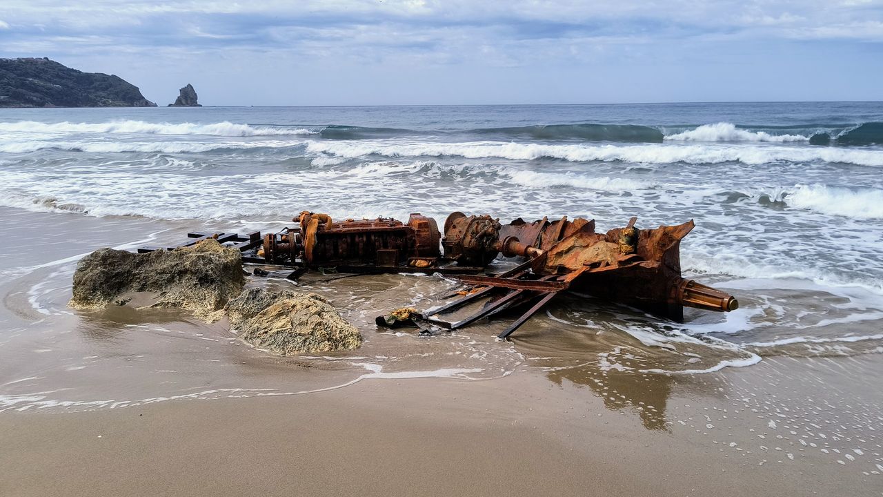 a dramatic view of a rusty shipwreck on a sandy corfu beach under clou