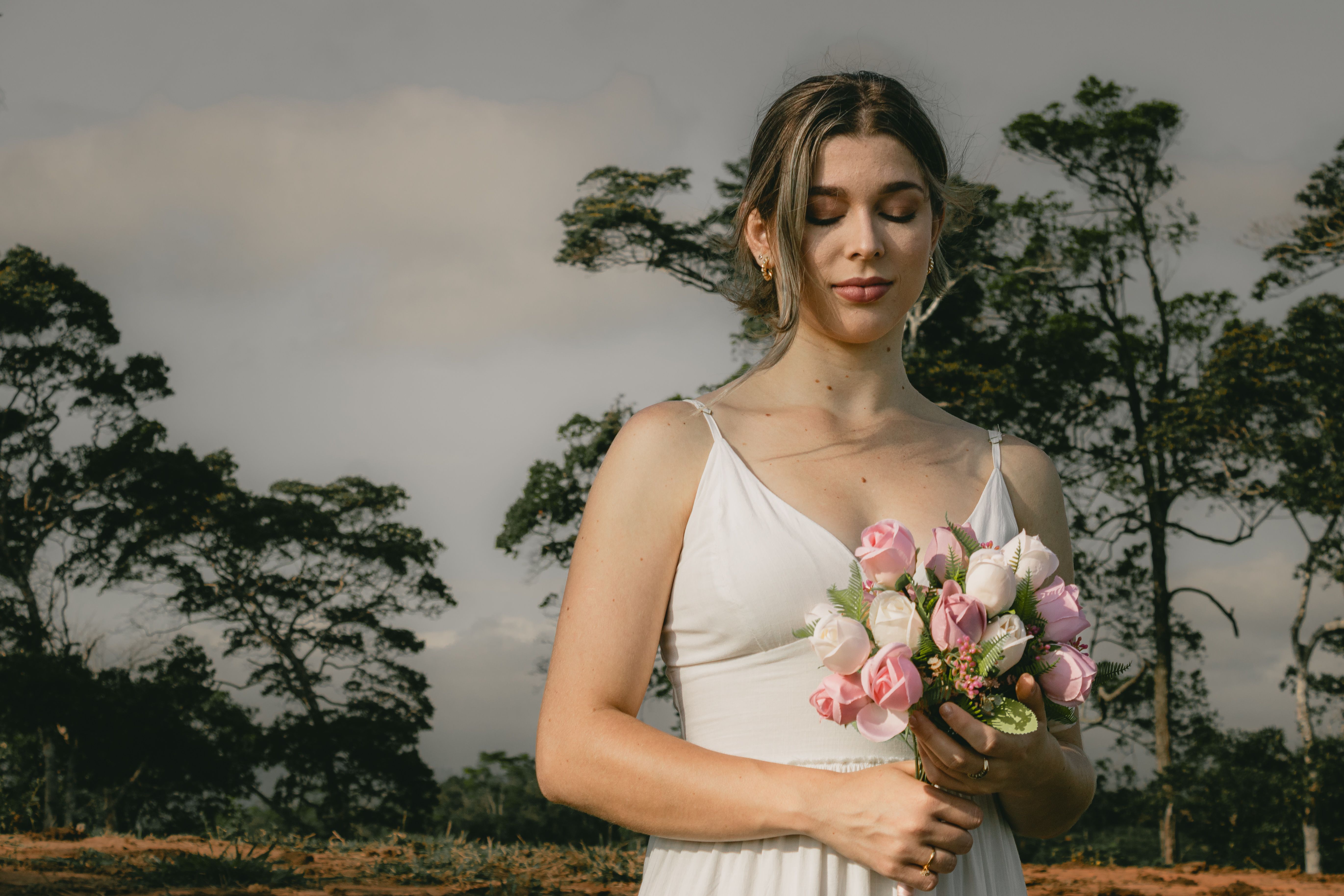 A woman in a white dress holding a bouquet · Free Stock Photo