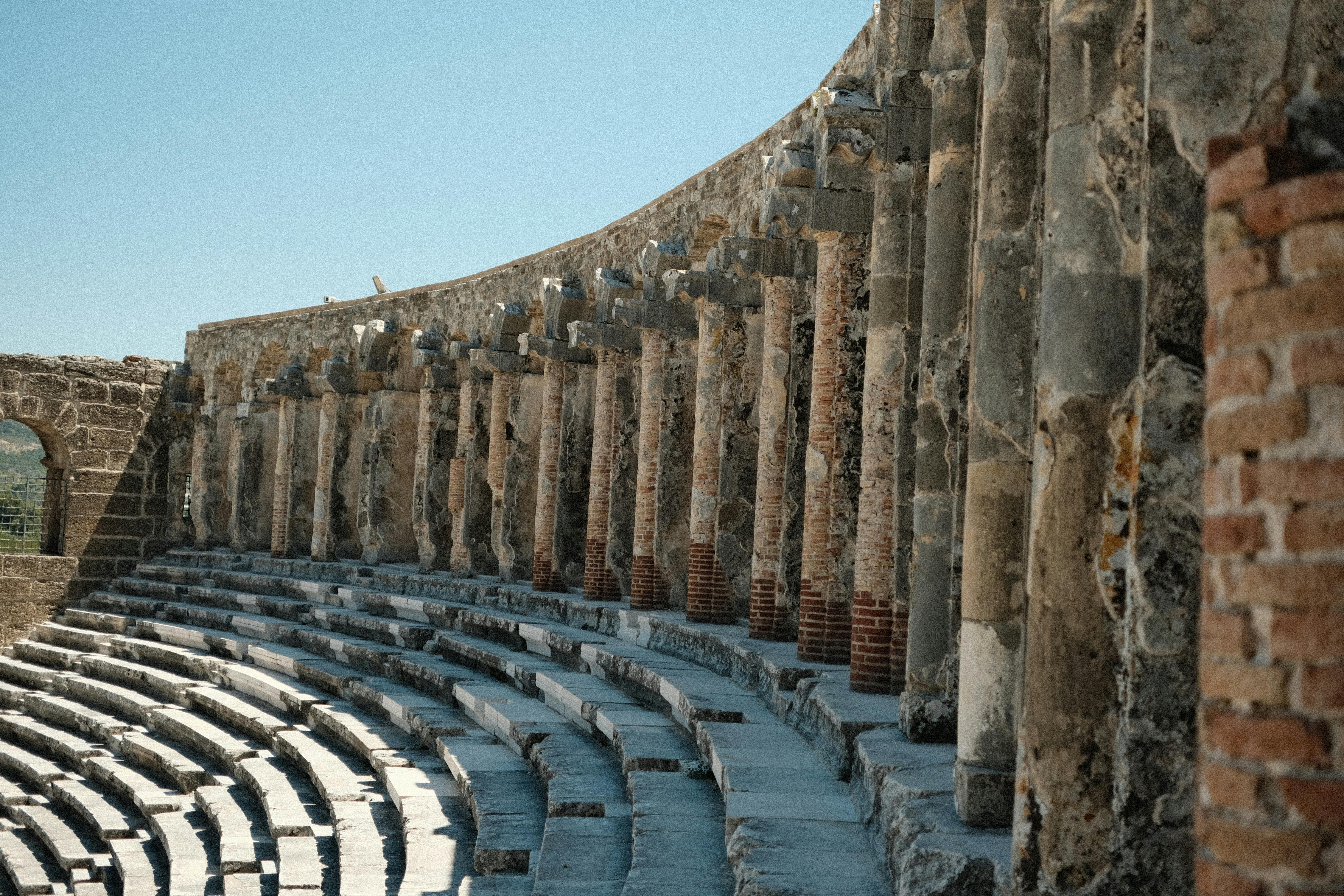 Free Explore the architectural beauty of ancient Roman amphitheater ruins with striking stone columns. Stock Photo