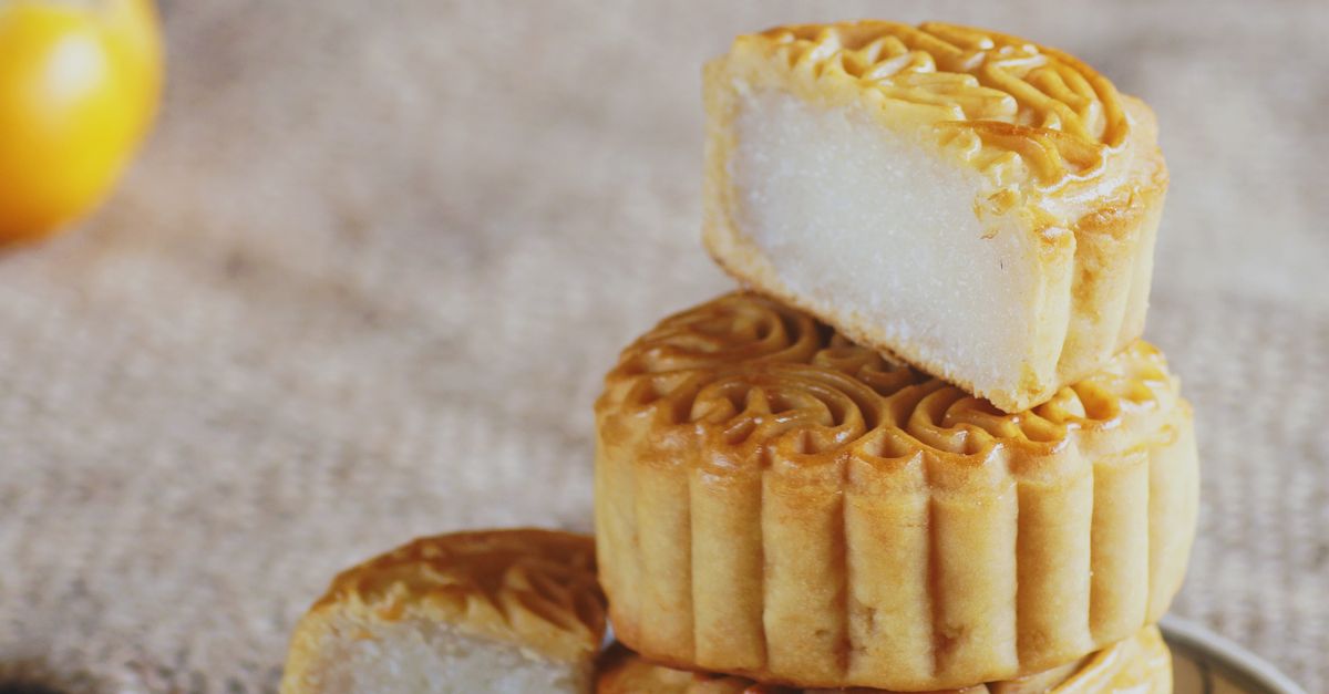Small Mooncake A stack of mooncakes on a plate with a small orange · Free Stock Photo