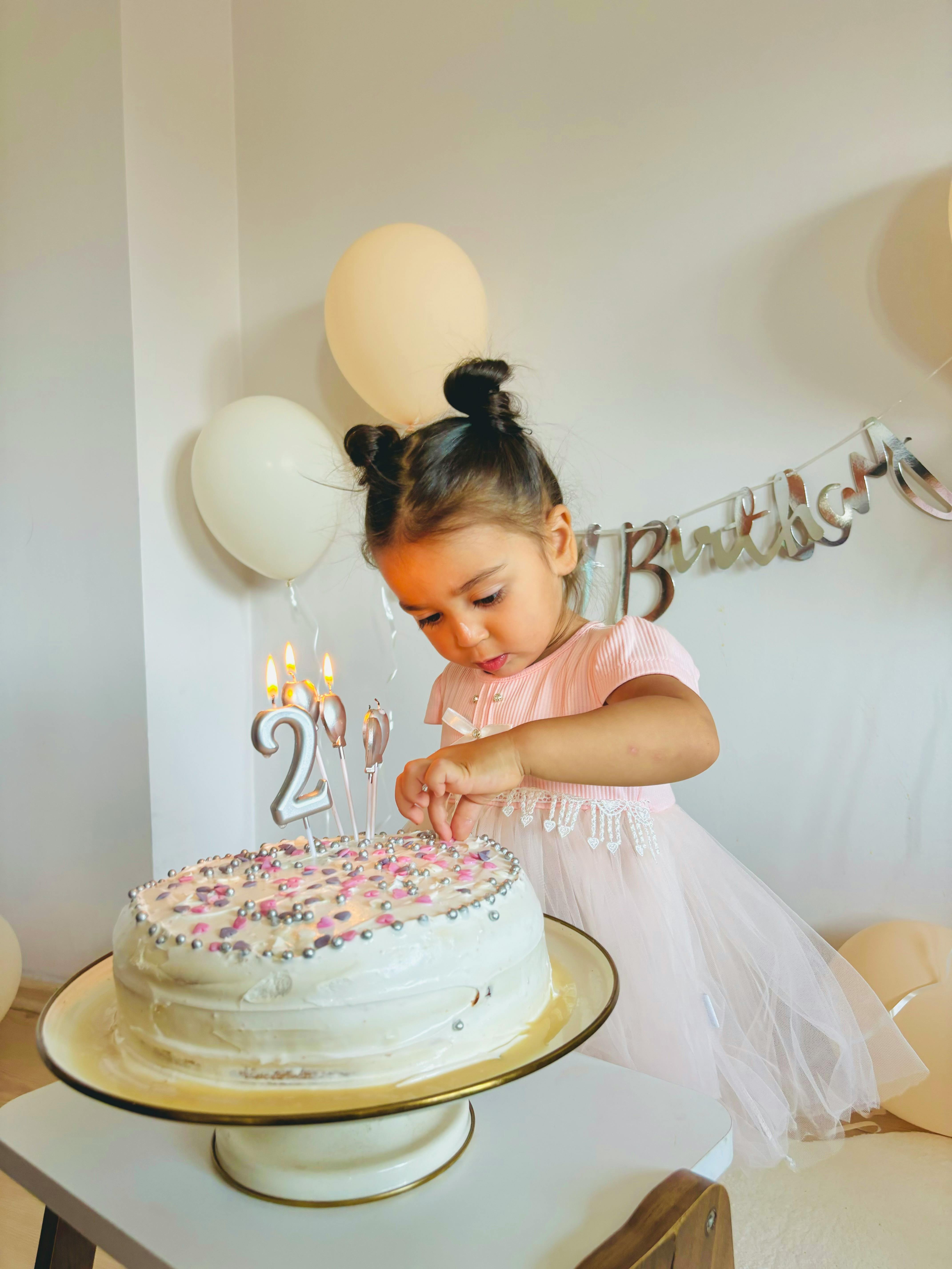 A little girl blowing out candles on her birthday cake