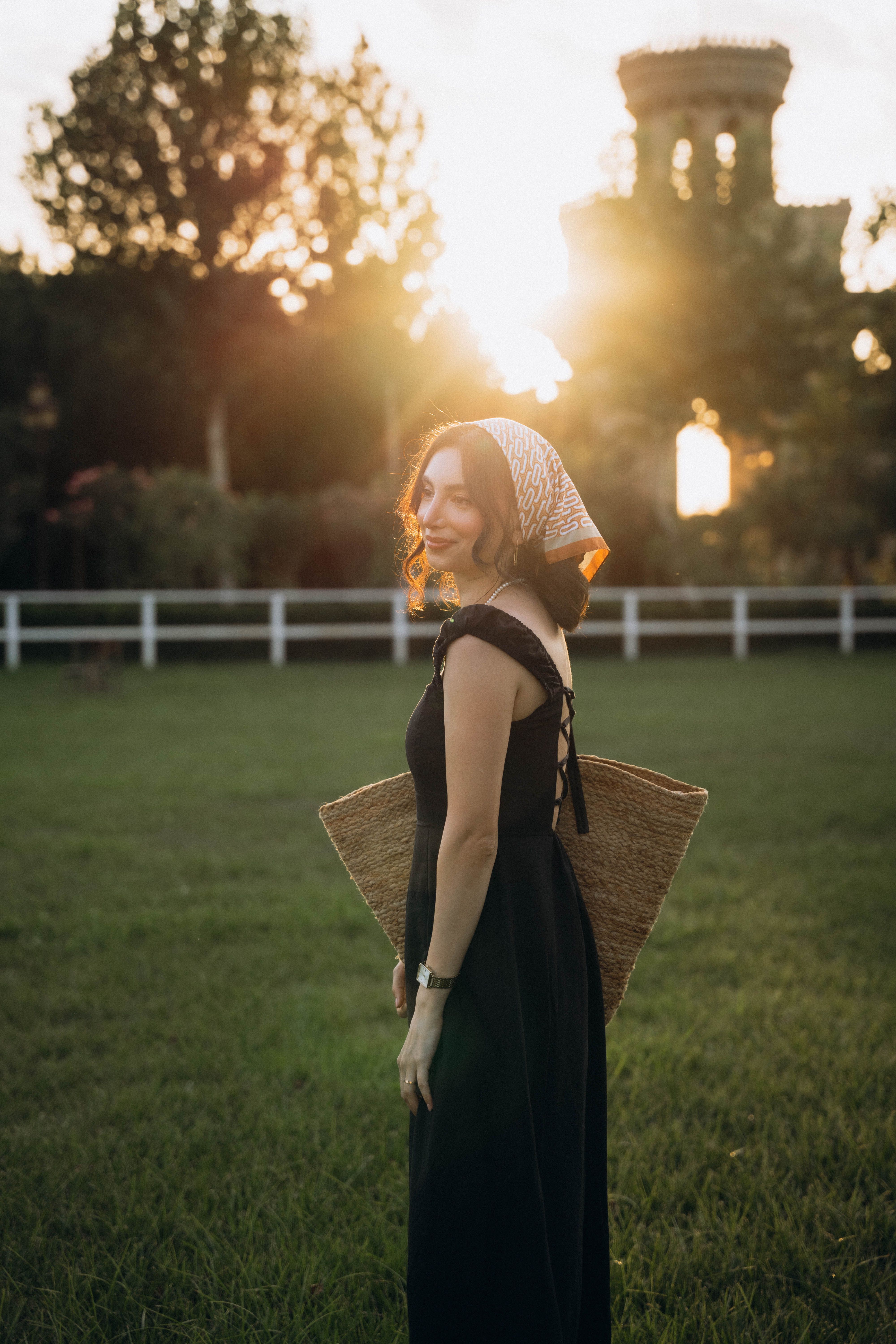 A woman in a black dress and straw hat at sunset · Free Stock Photo