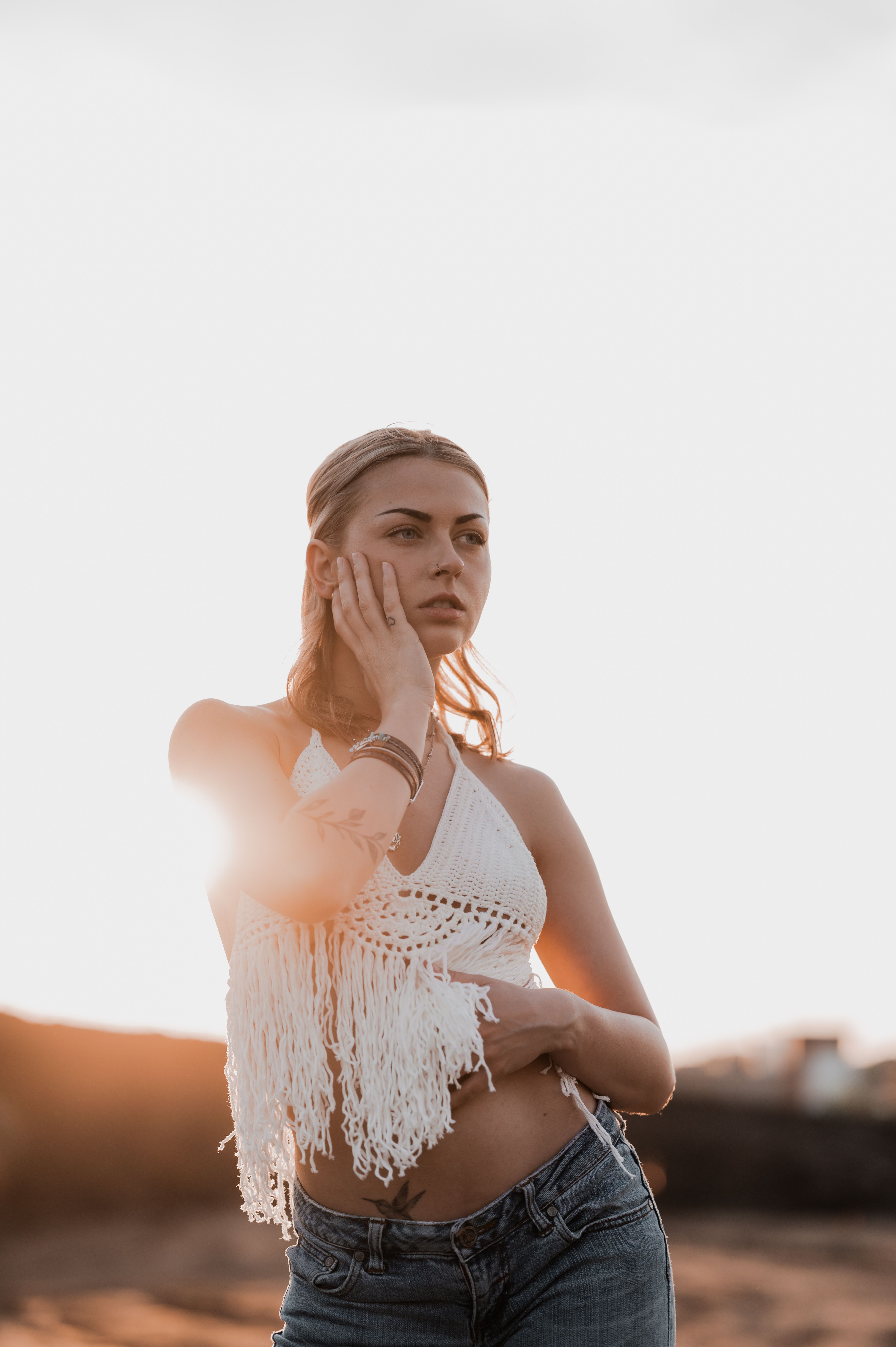 Stylish young woman in casual fashion posing outdoors with soft sunset lighting, creating a serene and elegant mood.. pexels,