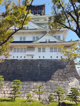大坂城绿树成荫，天空蔚蓝，景色壮丽