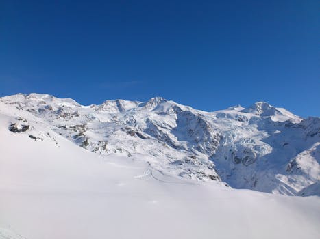 白雪皑皑的山脉在晴朗的蓝天下展现了冬天的宁静之美