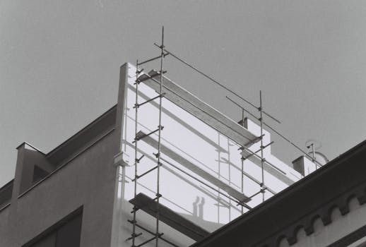 Monochrome image showcasing construction scaffolding on a building.