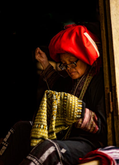 Фотография женщины за шитьем одежды