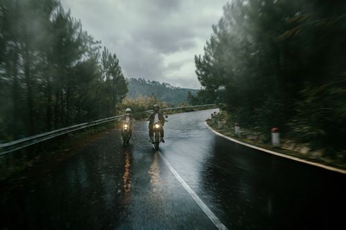 Free Two motorcyclists ride on a wet forest road during a rainy, overcast day. Stock Photo