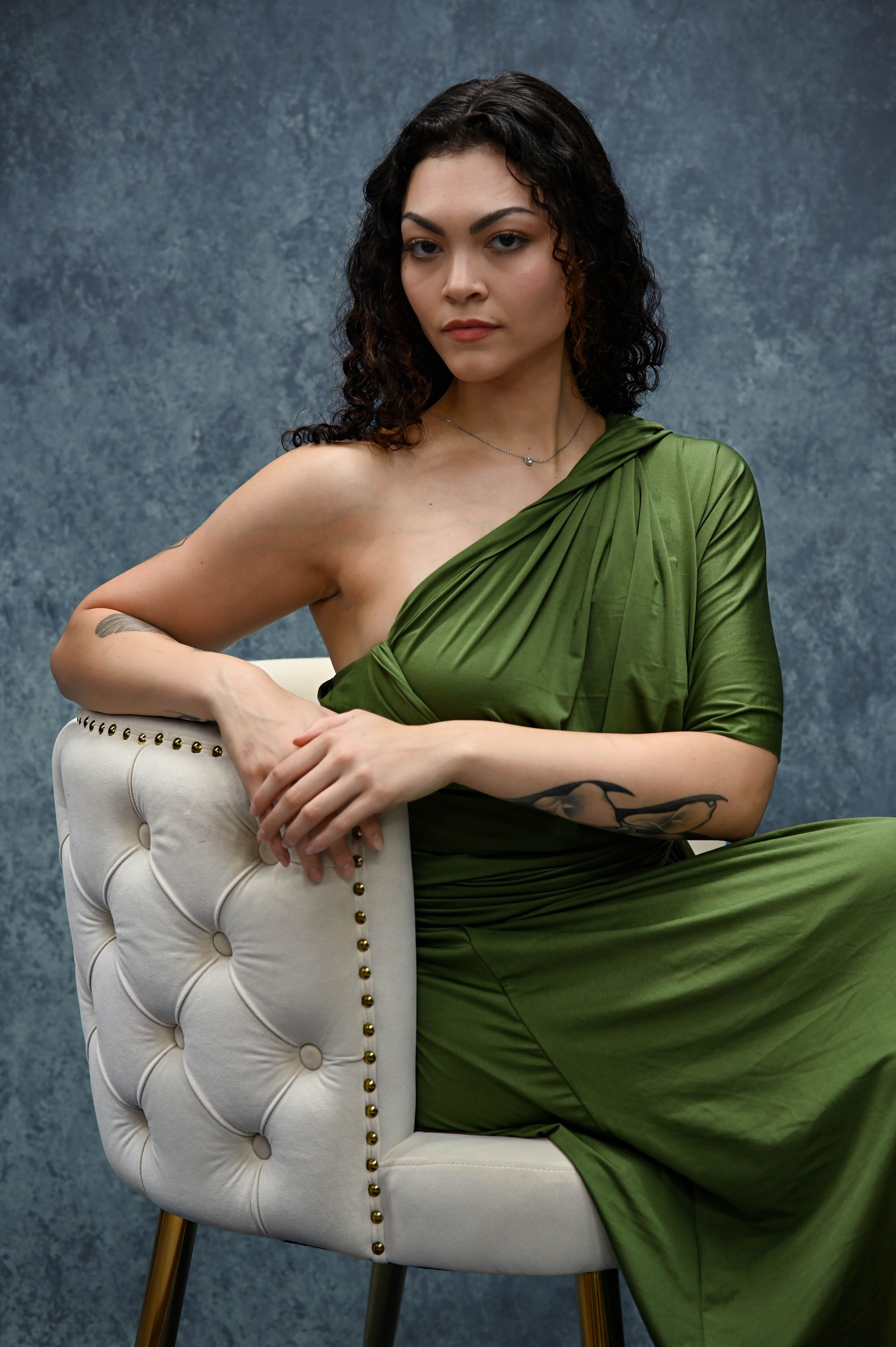 A woman in a green dress sitting on a chair · Free Stock Photo