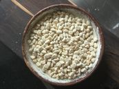 Close-up of a wooden bowl filled with traditional Indian puffed rice on a wooden surface.