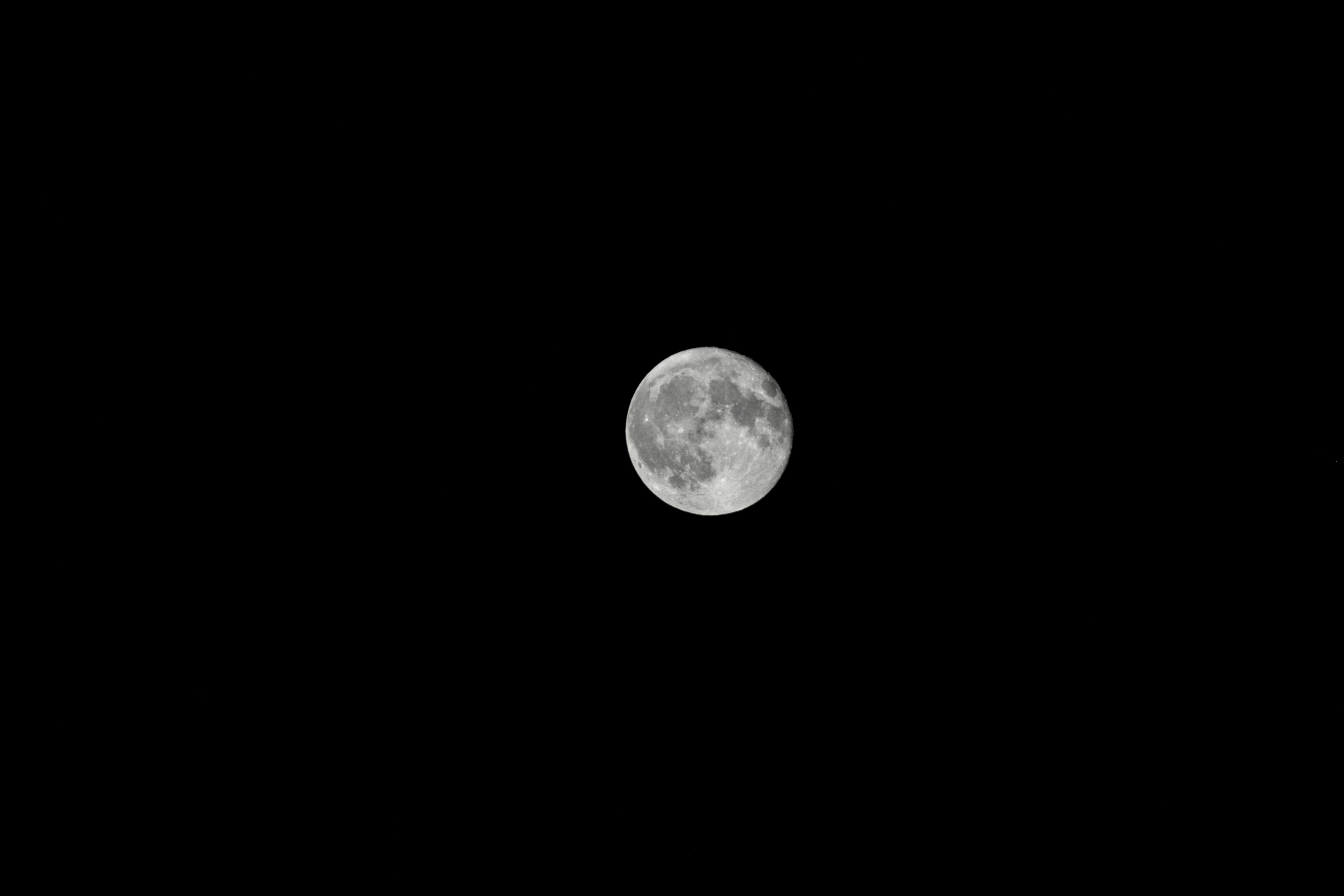 a full moon is seen in the night sky