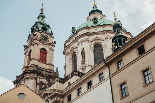 Free Close-up of Baroque architecture featuring the dome and clock tower of St. Nicholas Church in Prague. Stock Photo