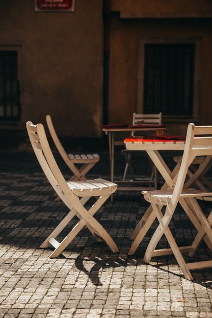 Sunlit outdoor patio setting with vintage wooden chairs and table